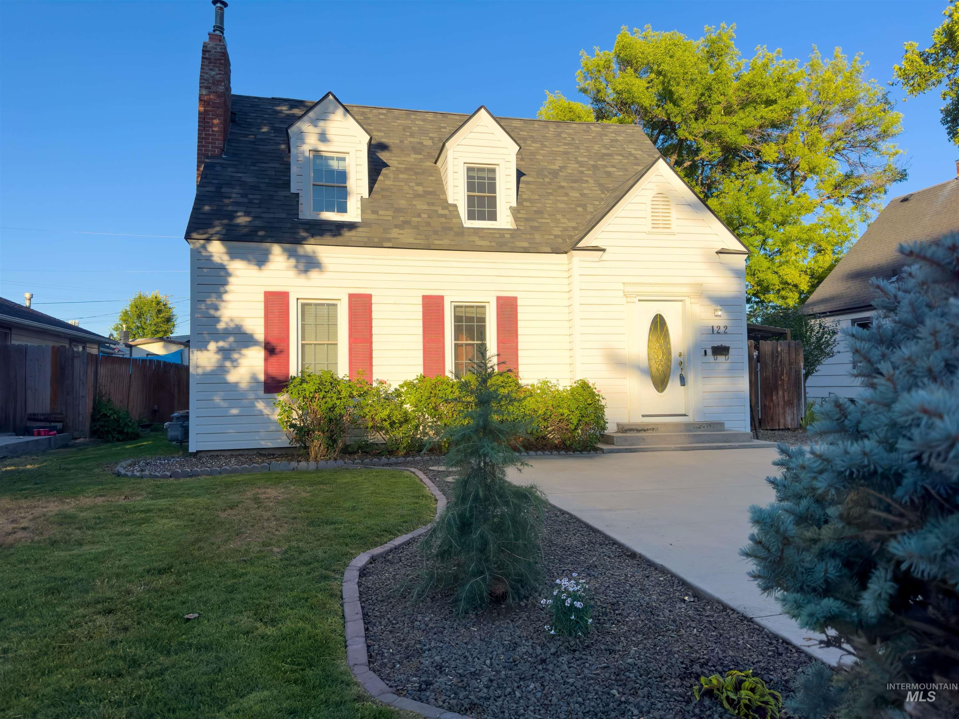 Cape cod home featuring a chimney