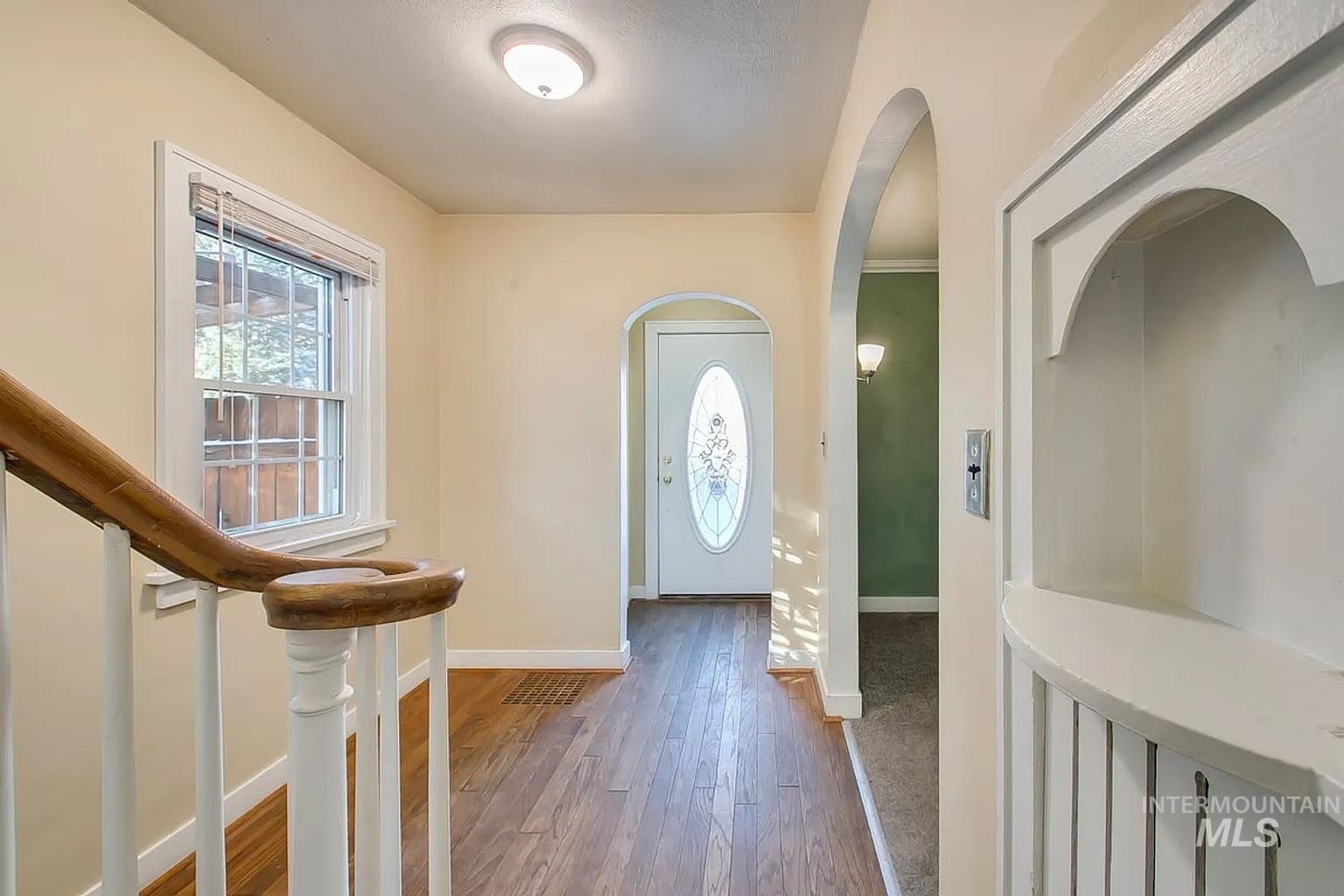 Entrance foyer featuring wood-type flooring and arched walkways
