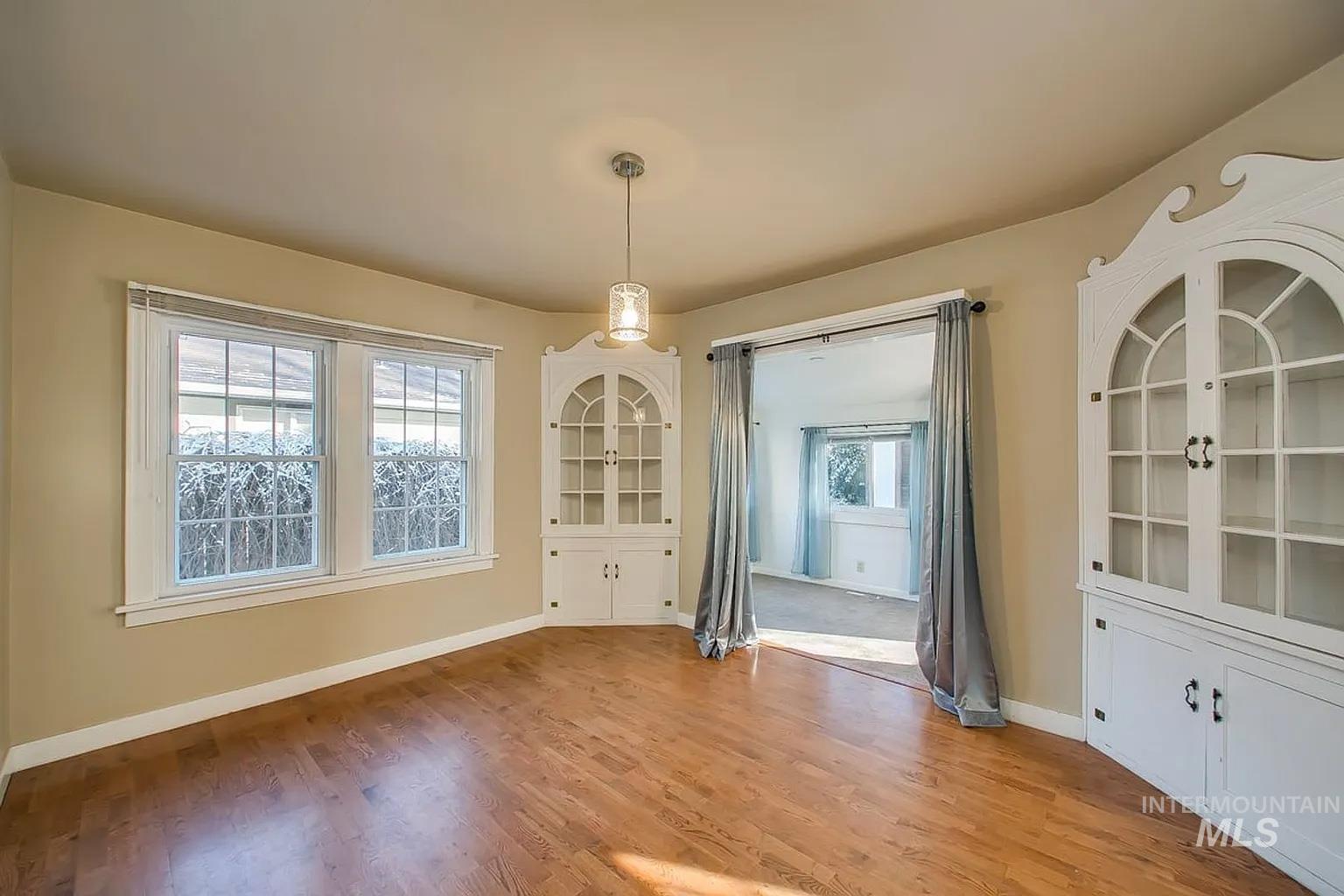 Unfurnished dining area with light wood-style flooring and baseboards