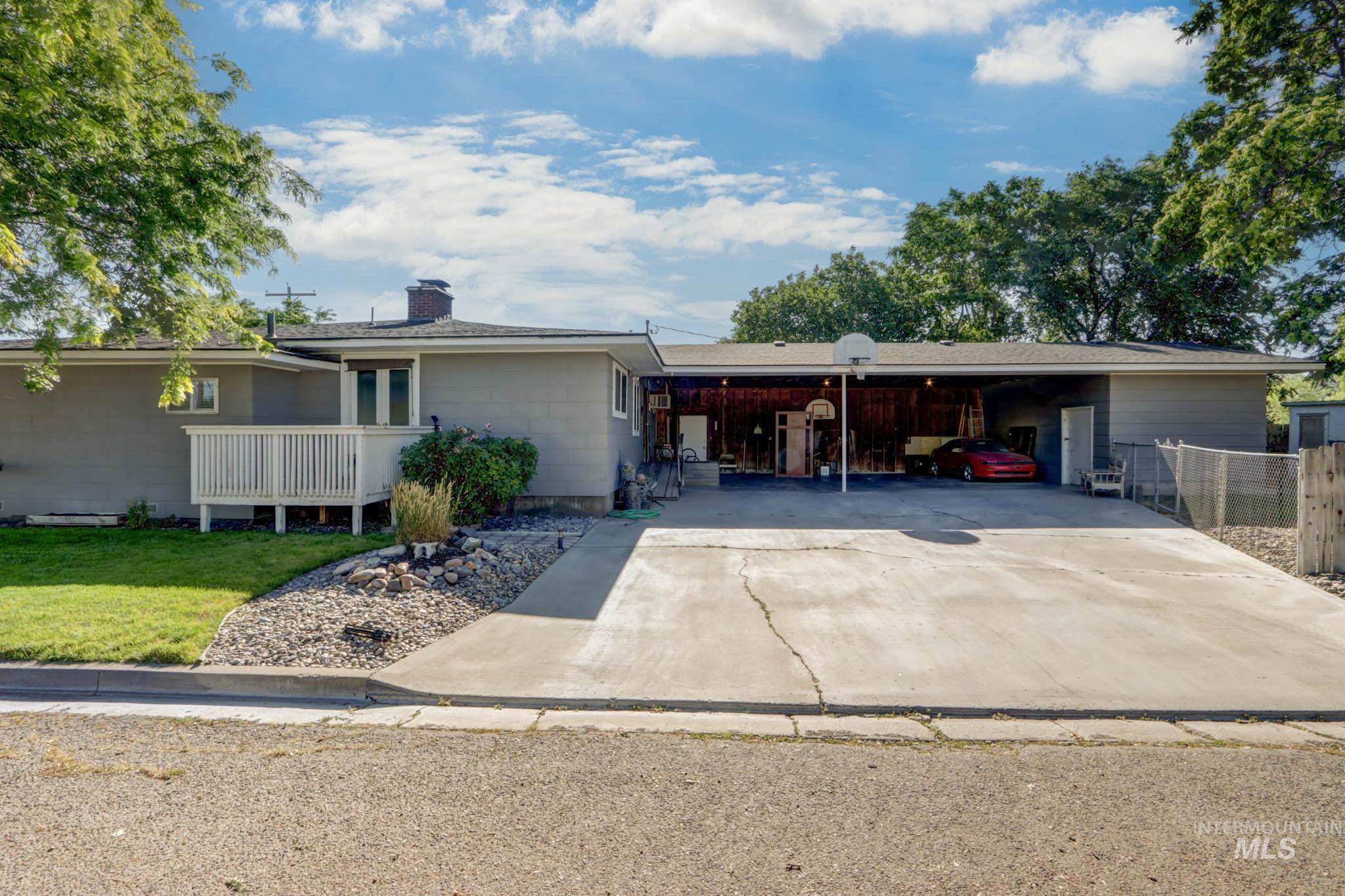 Single story home with concrete driveway, an attached carport, and a chimney