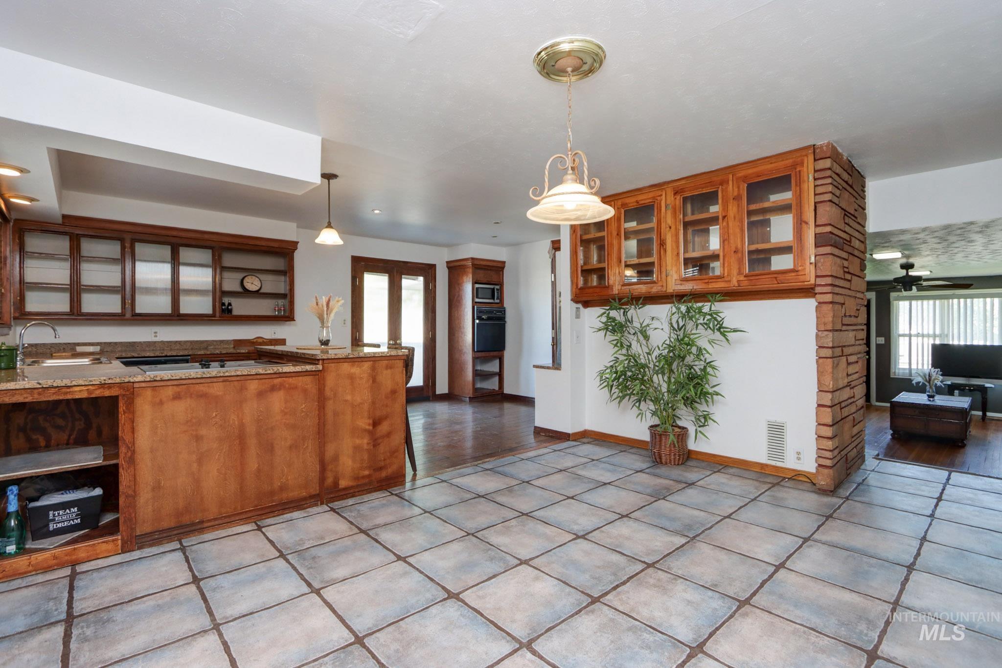 Kitchen with brown cabinets, black appliances, and healthy amount of natural light