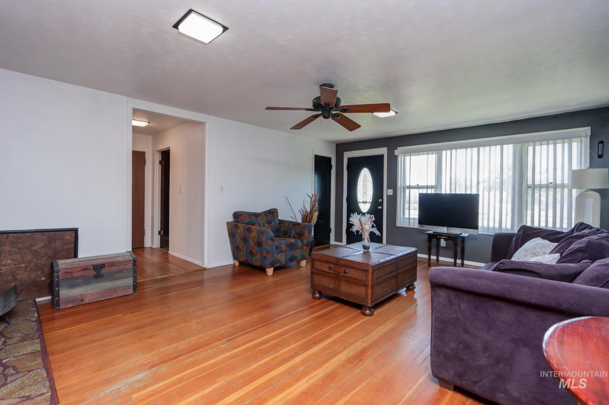 Living room with light wood-style floors and a ceiling fan