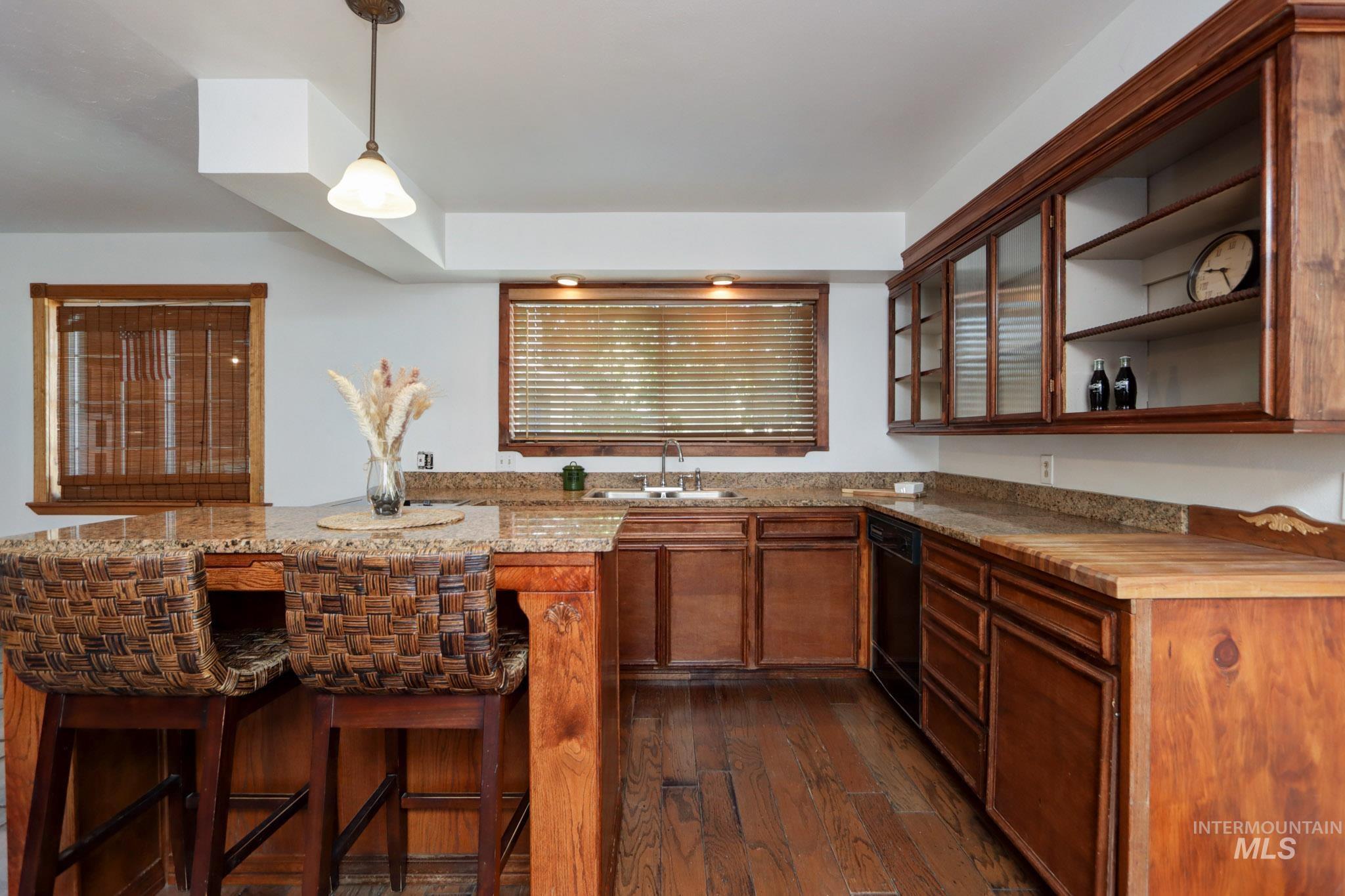 Bar with dishwasher, dark wood-style floors, and decorative light fixtures
