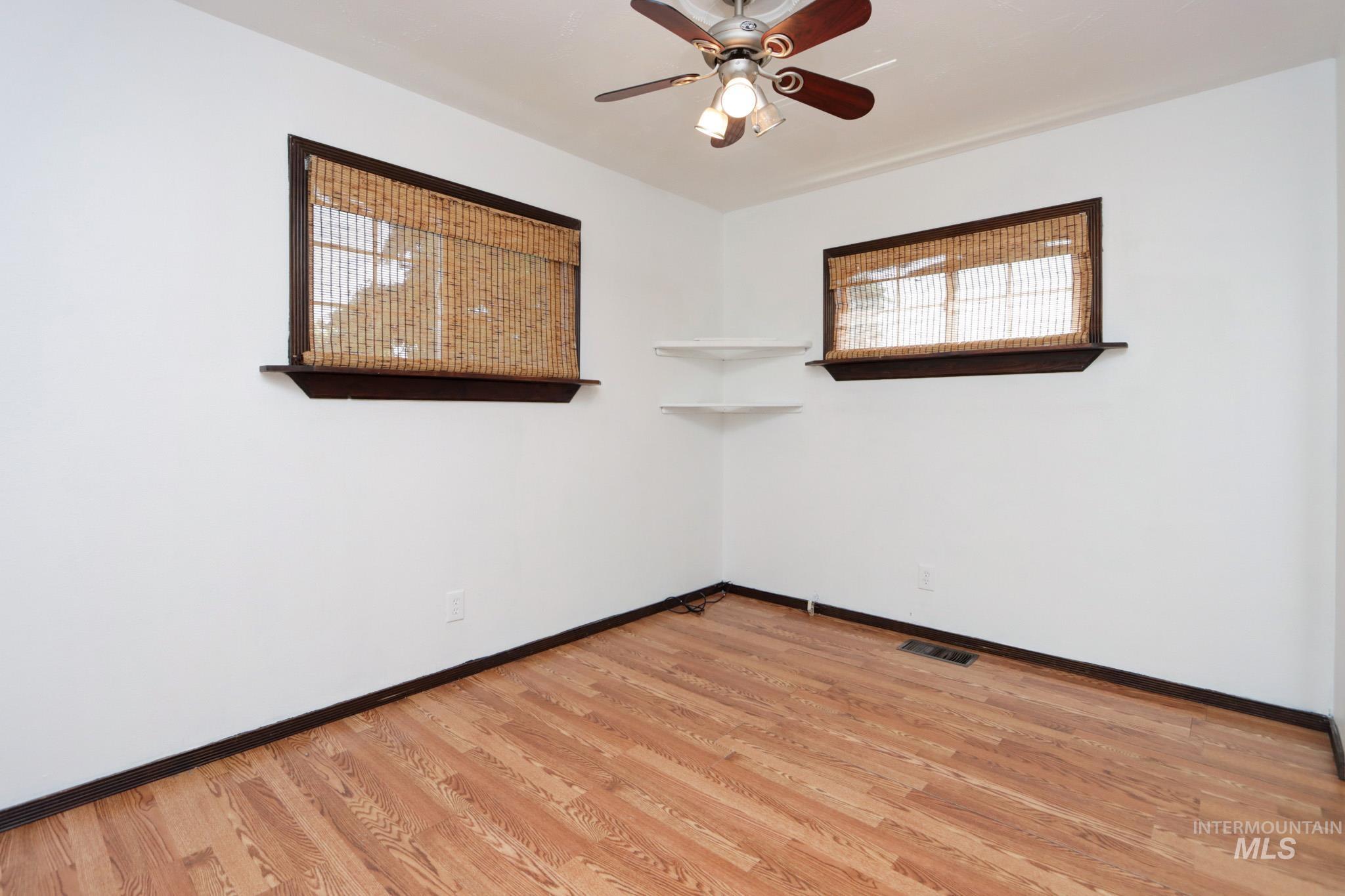 Empty room featuring a ceiling fan and wood finished floors