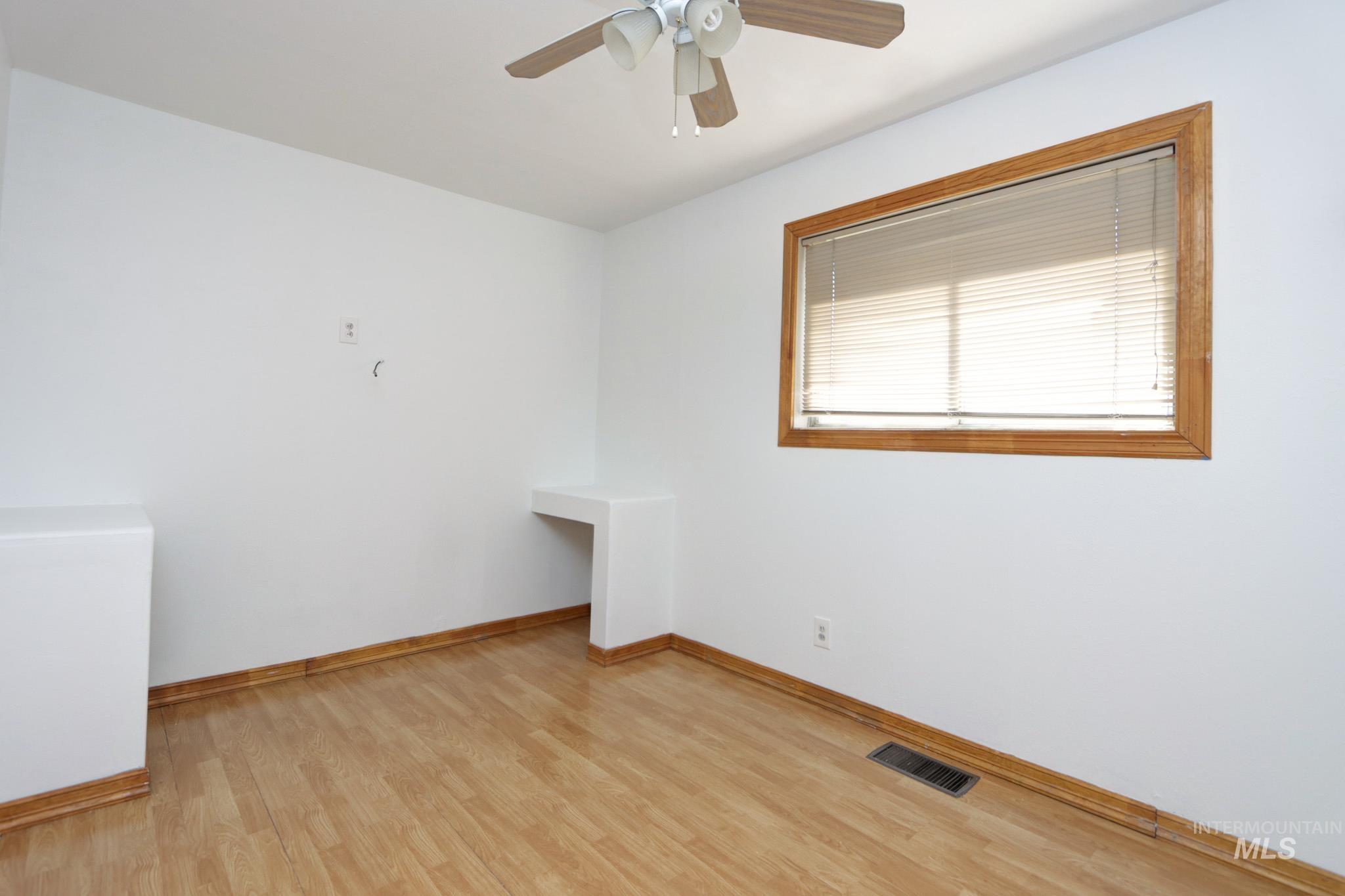 Unfurnished room with light wood-type flooring and ceiling fan