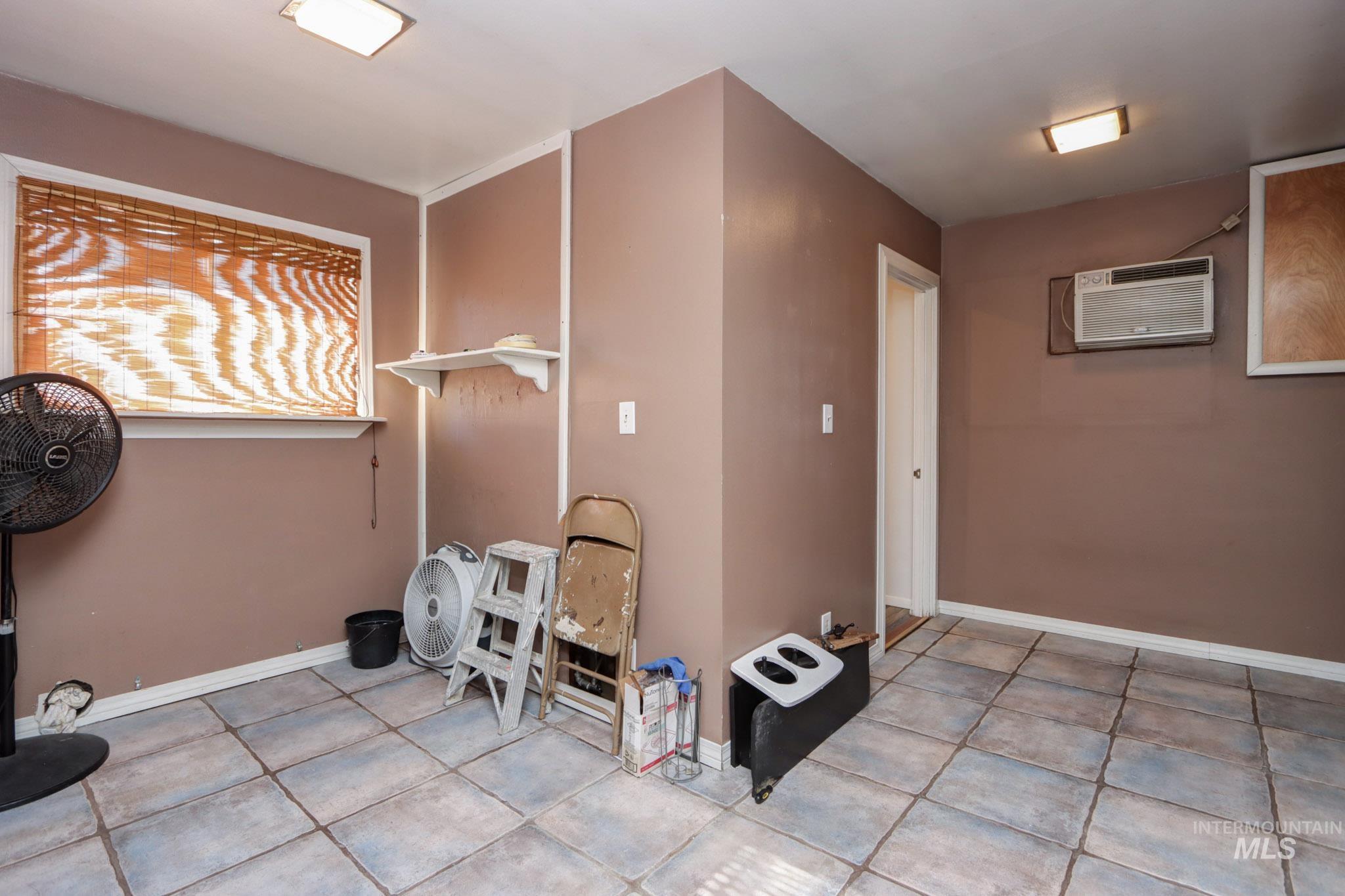 Washroom with tile patterned floors and a wall mounted air conditioner