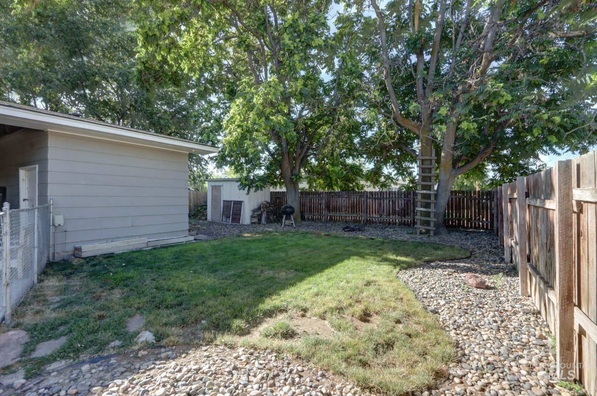 Fenced backyard with an outdoor structure