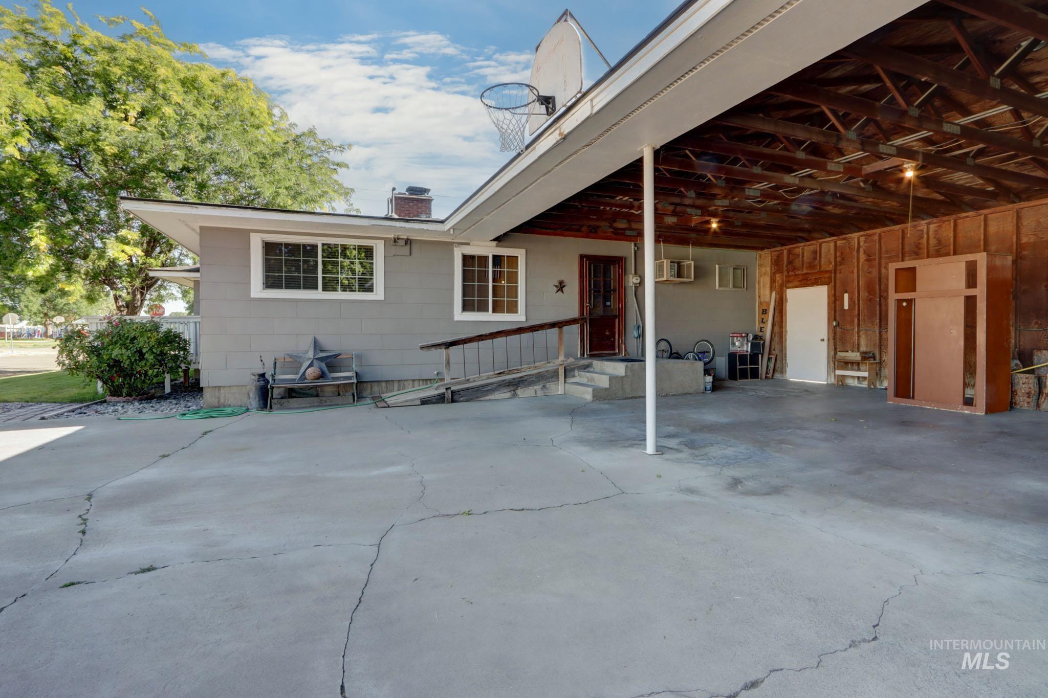Rear view of property with a wall mounted AC, a chimney, and an attached carport