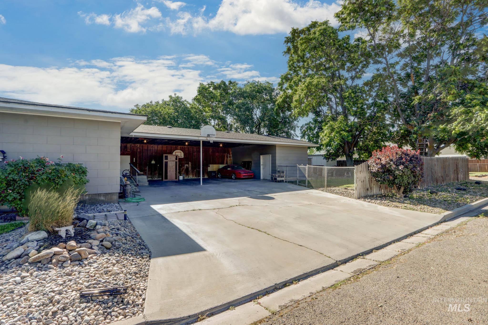 View of parking featuring an attached carport and concrete driveway