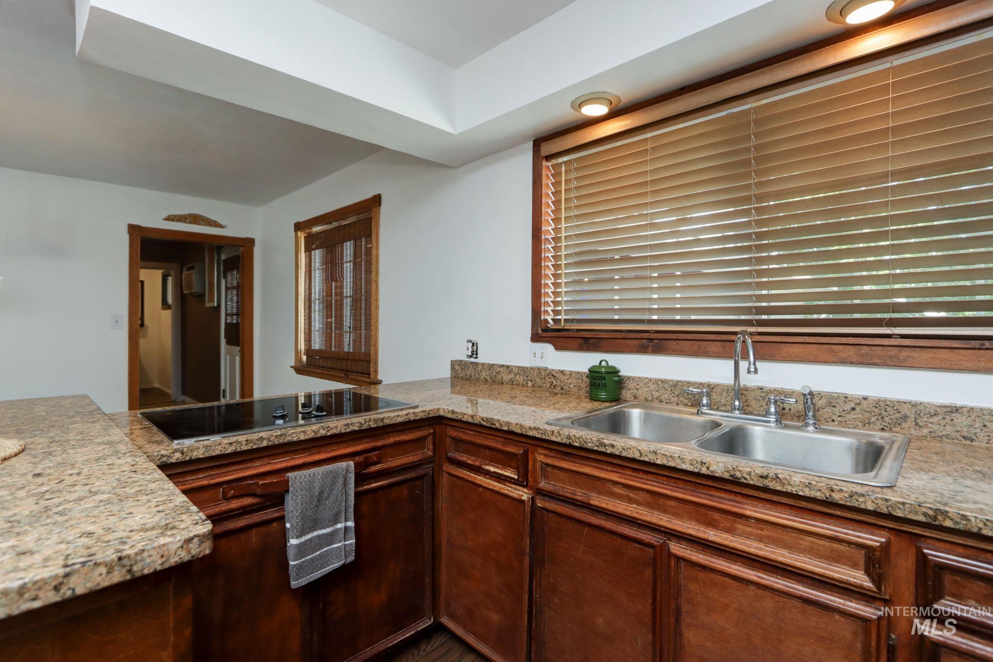 Kitchen featuring black electric stovetop, light countertops, and a peninsula