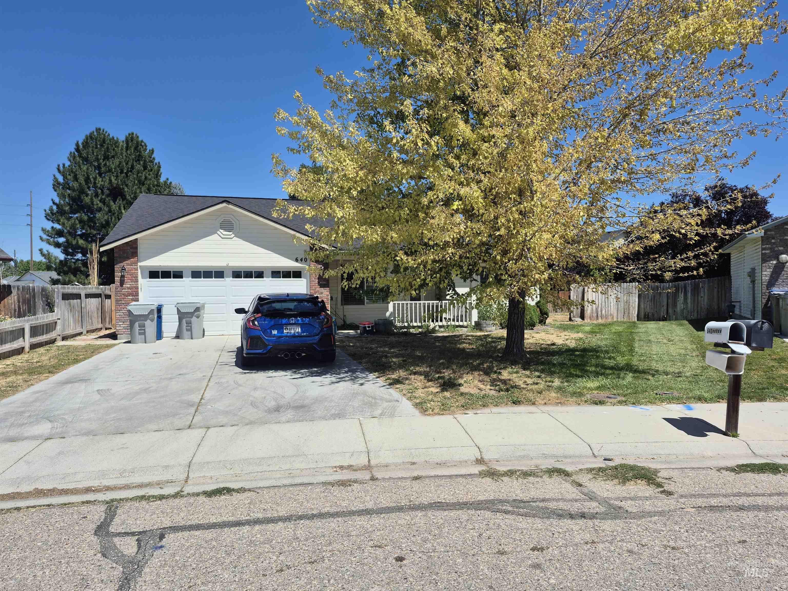 View of front of home with a garage, concrete driveway, and brick siding