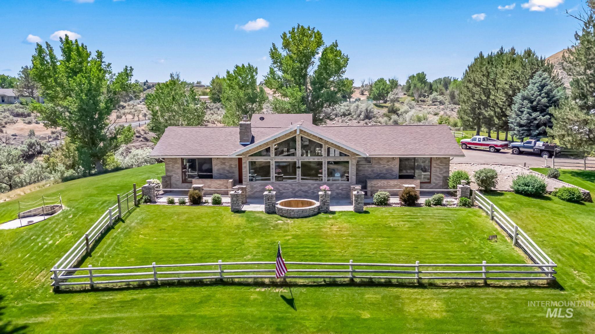 Back of house with a fenced backyard, a chimney, an outdoor fire pit, and a patio
