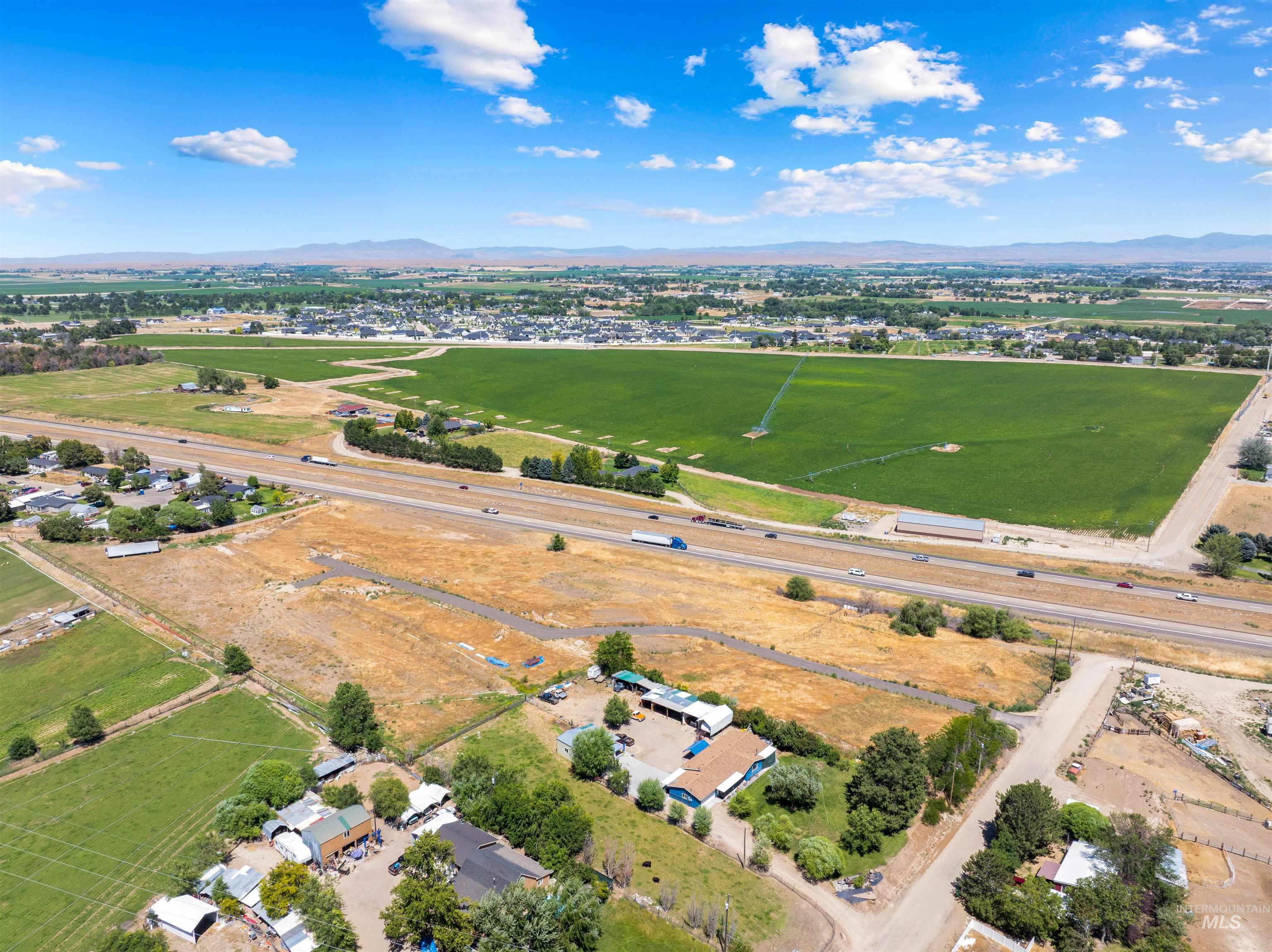 Aerial view of property and surrounding area featuring a mountainous background