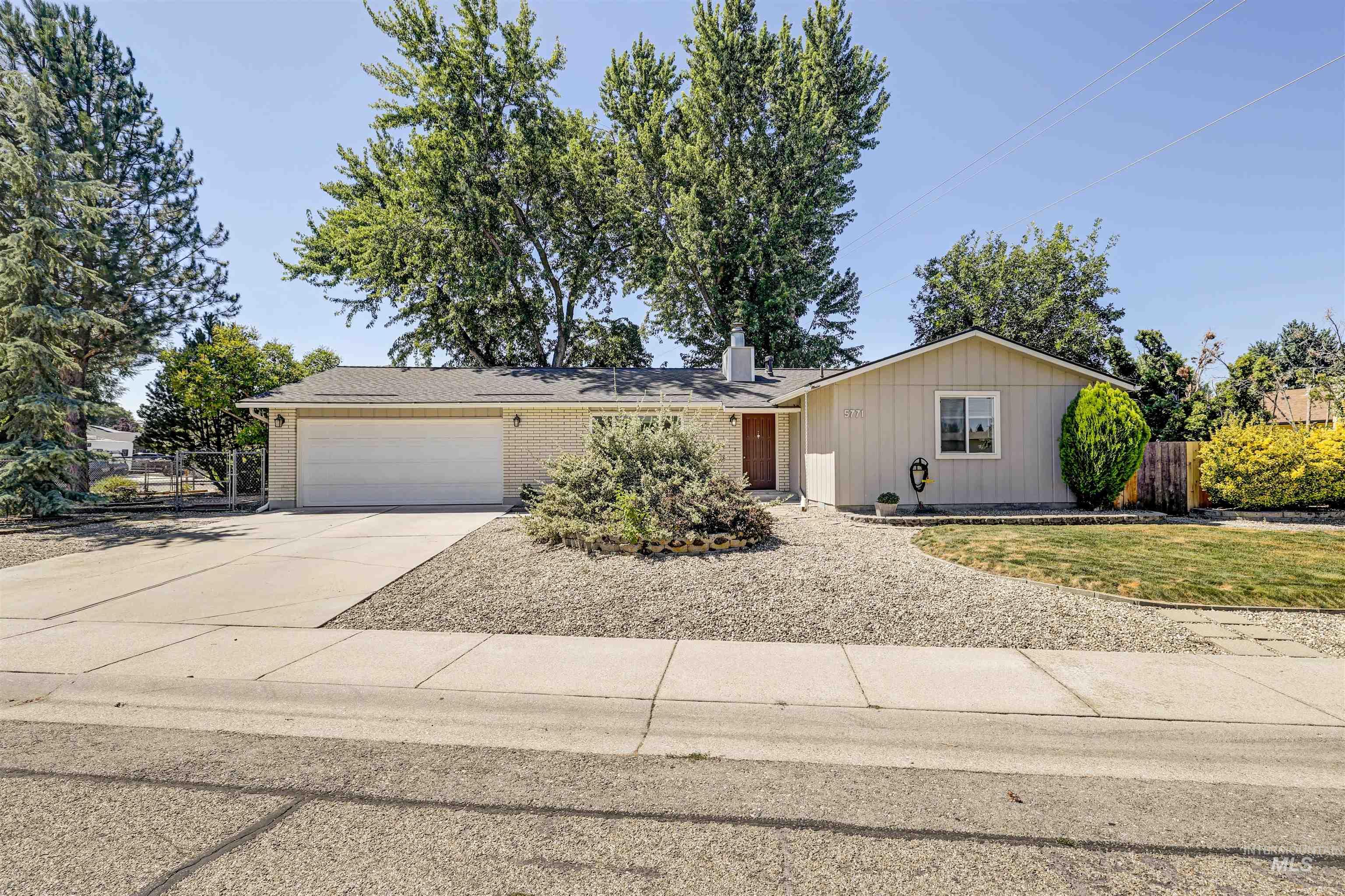Ranch-style house with driveway, an attached garage, and brick siding