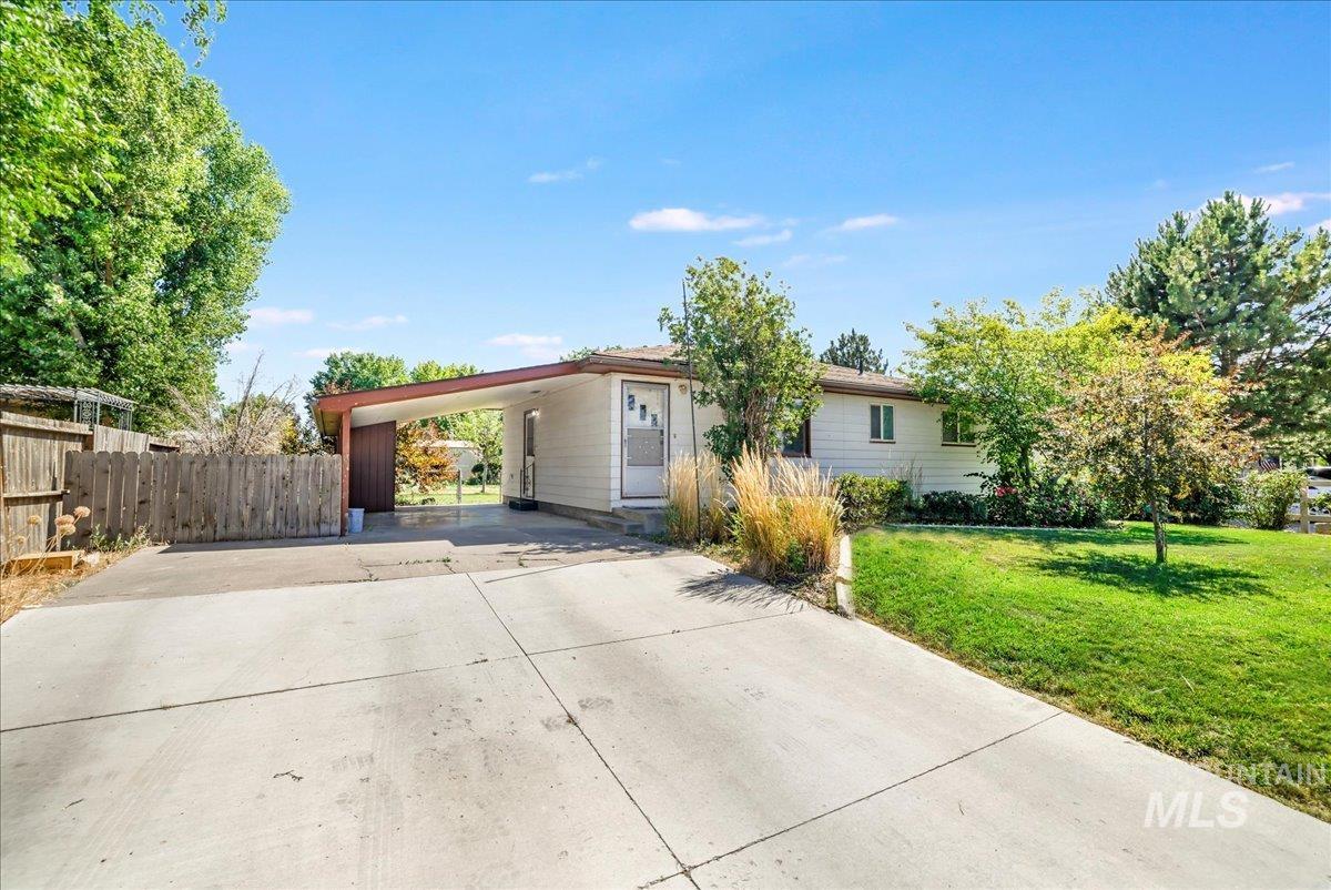 View of front of property featuring an attached carport and concrete driveway