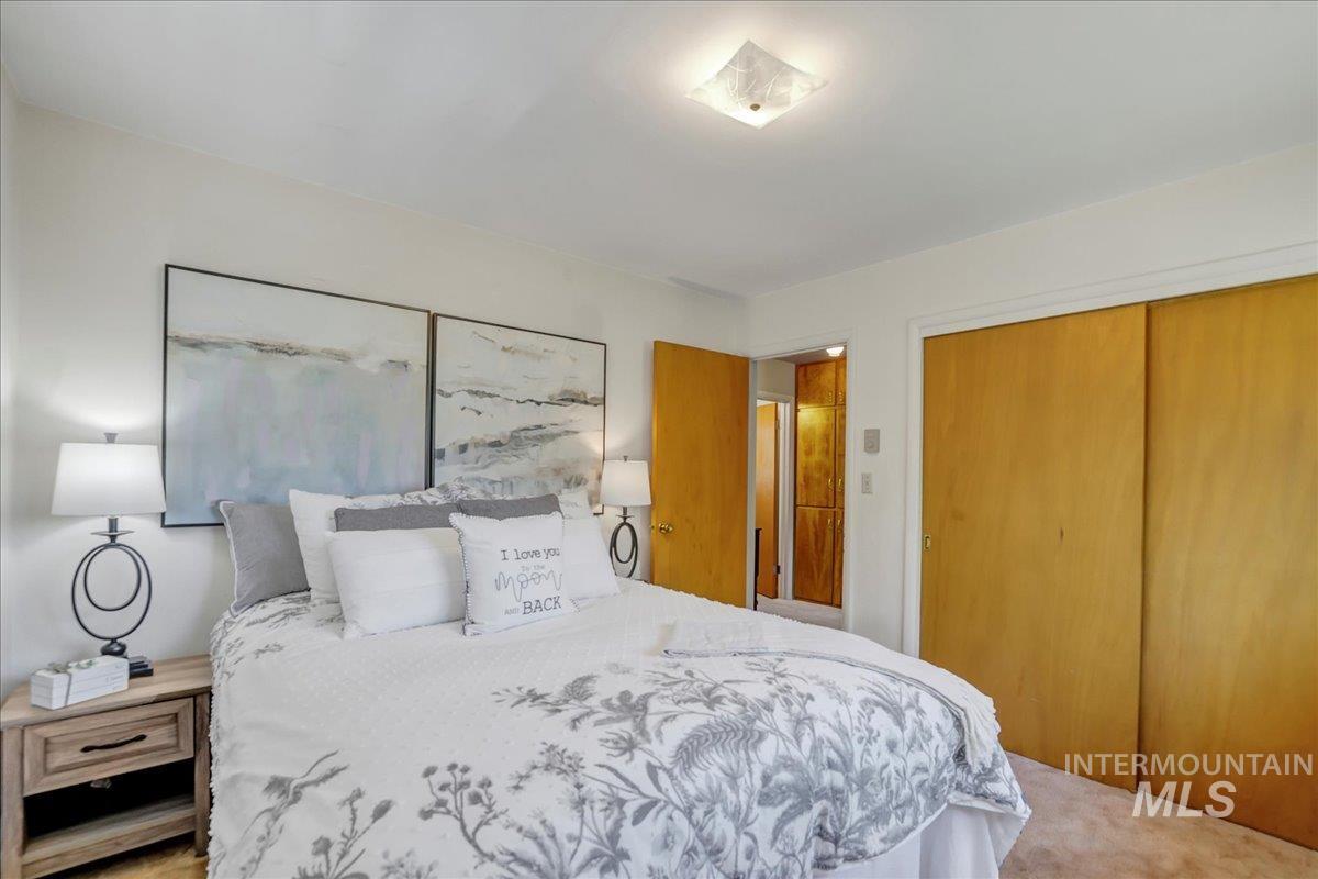 Carpeted bedroom featuring a closet