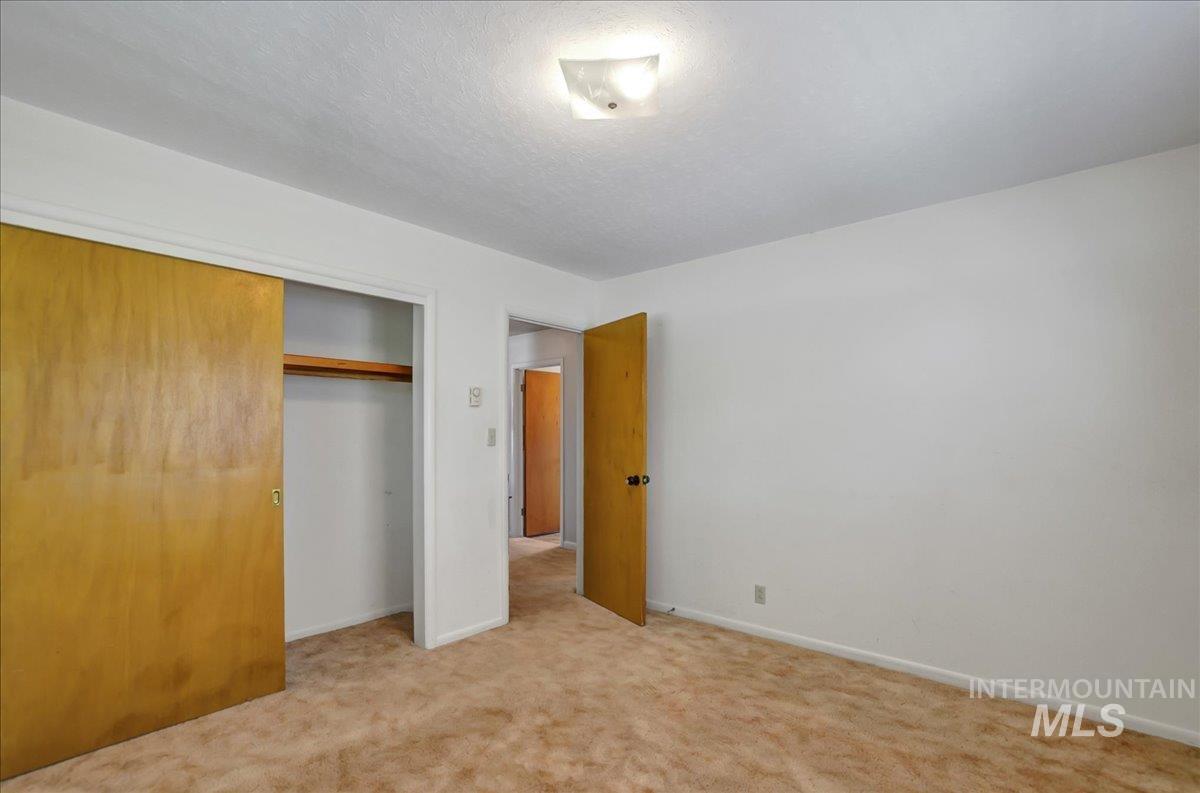Unfurnished bedroom featuring carpet flooring, a closet, and a textured ceiling