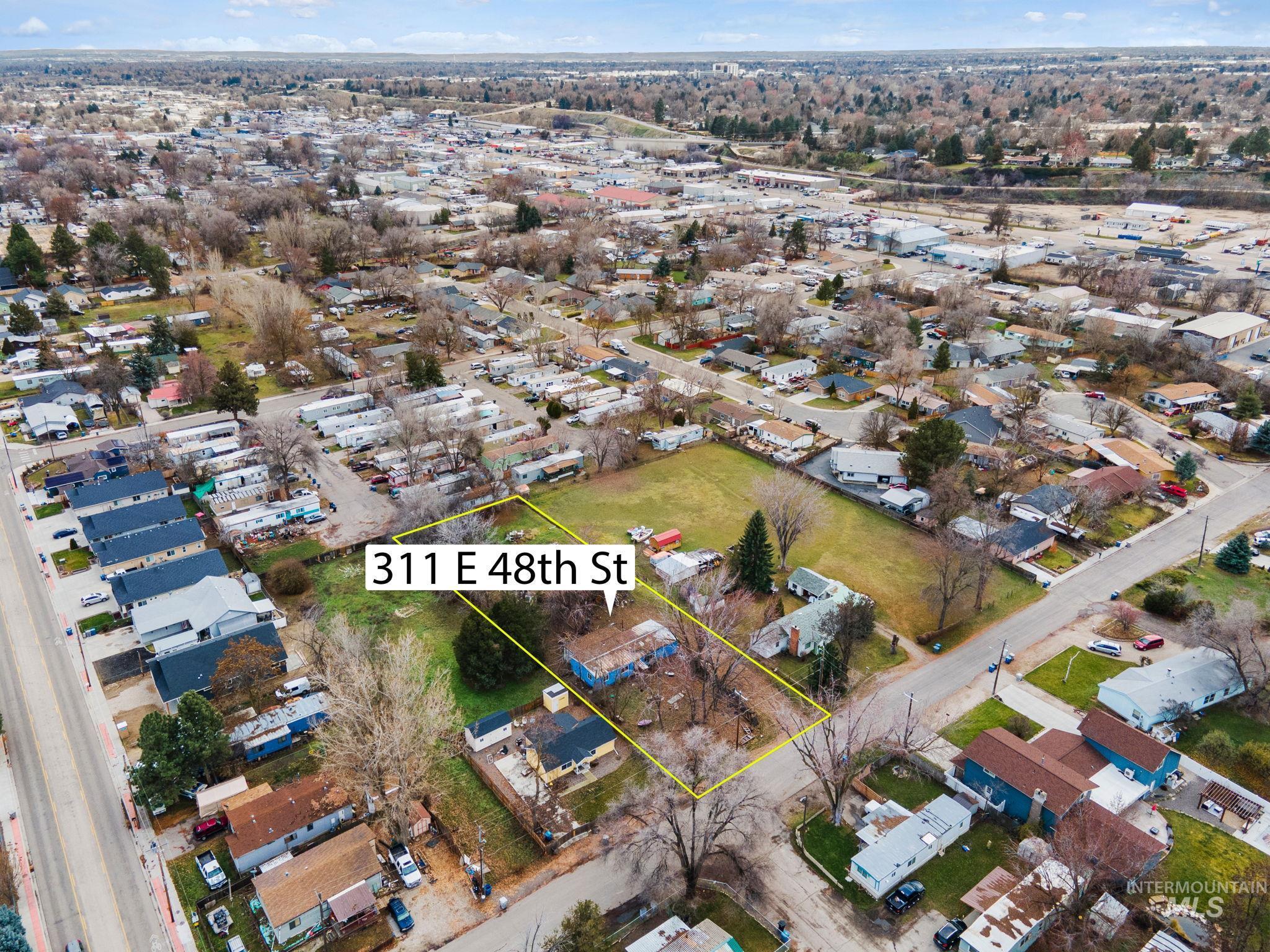 Aerial view of property and surrounding area with property parcel outlined