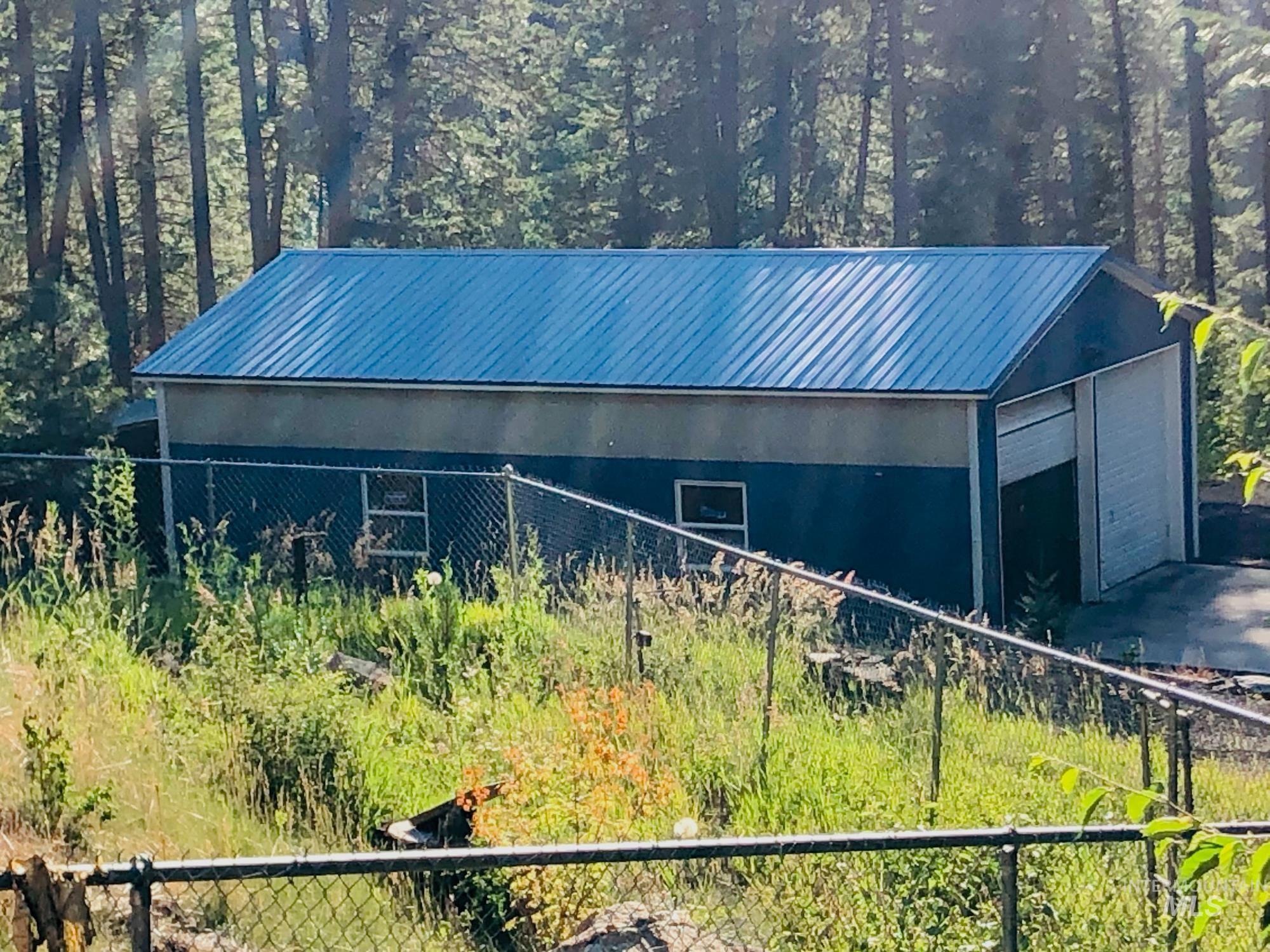 View of side of home with a metal roof, an outdoor structure, and a garage