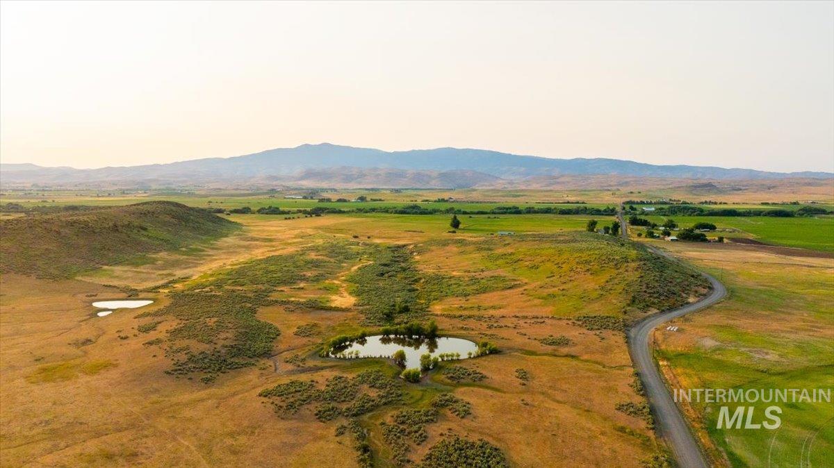 Aerial view of property and surrounding area featuring a mountainous background