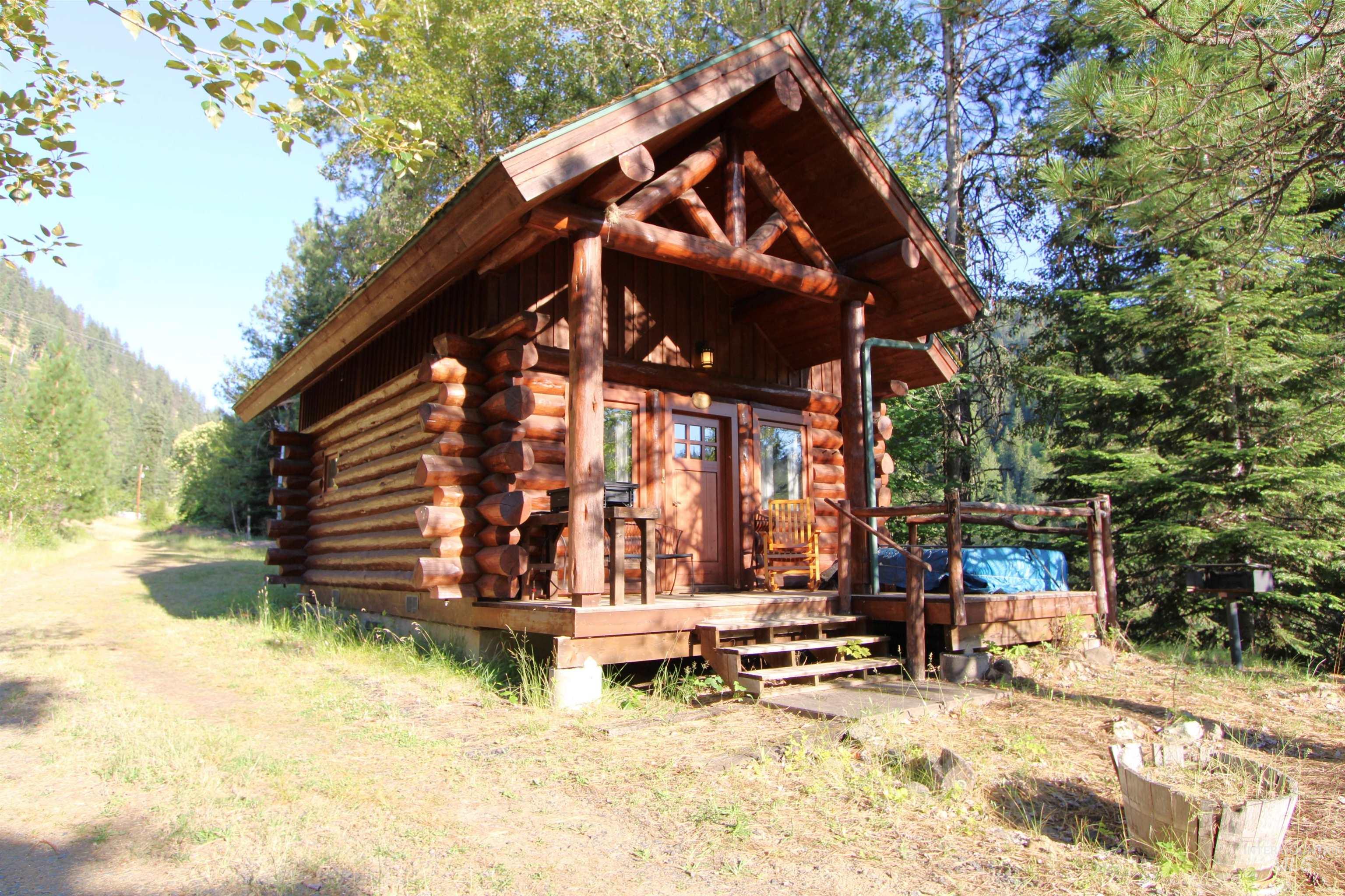 View of front facade with log siding and a deck