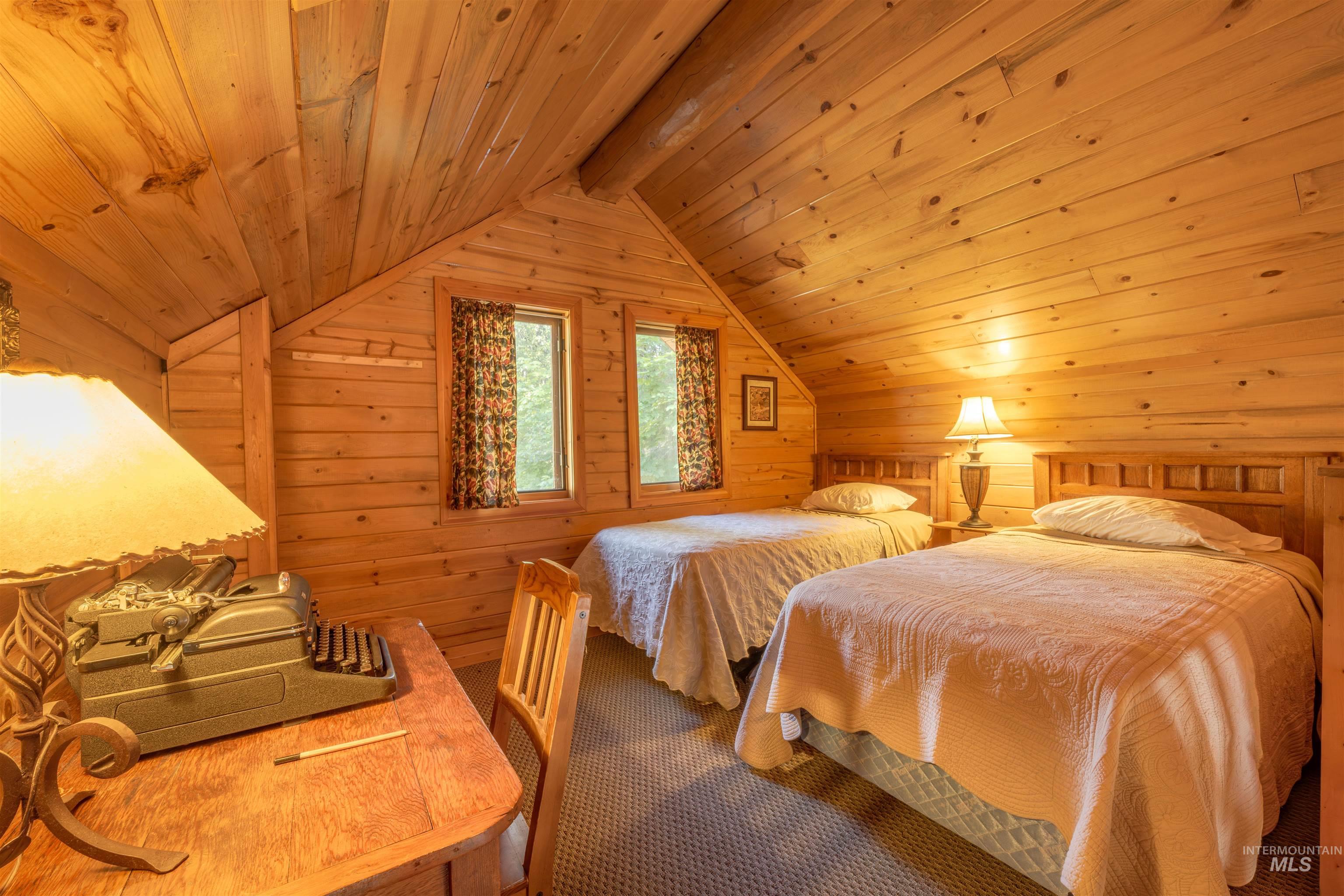 Bedroom with wood walls, wood ceiling, and vaulted ceiling