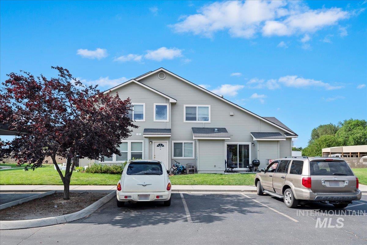 Traditional home featuring uncovered parking and a front lawn