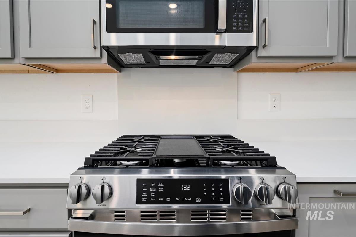 Kitchen view of appliances with stainless steel finishes, gray cabinetry, and light countertops
