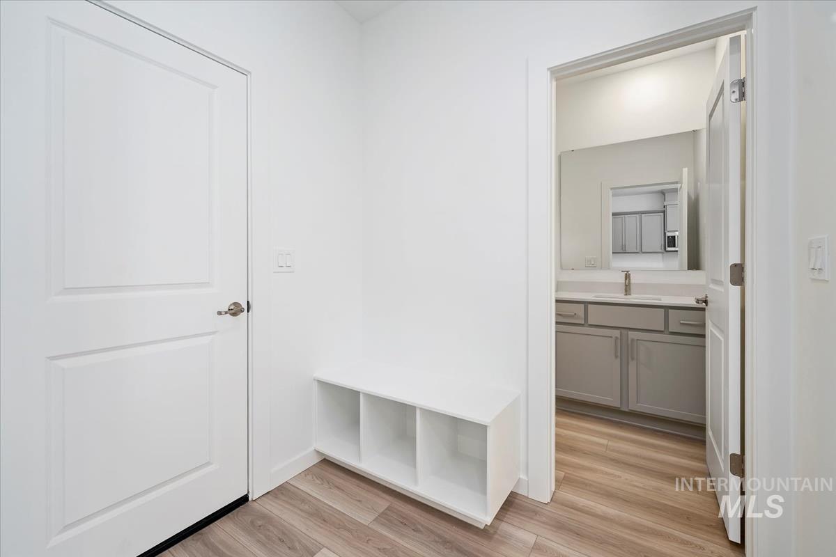 Mudroom with light wood-type flooring and a sink