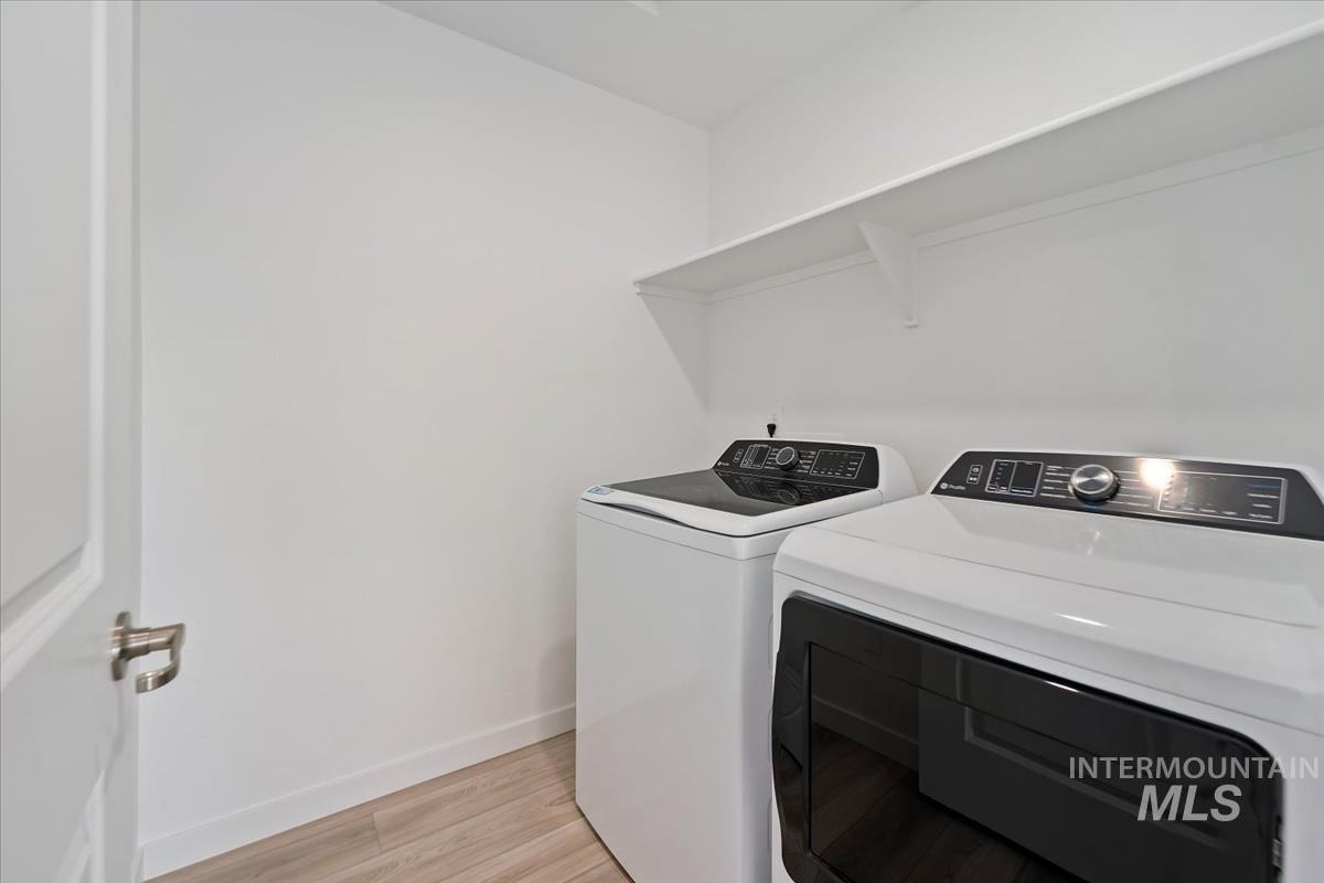 Washroom featuring washing machine and clothes dryer and light wood-style floors