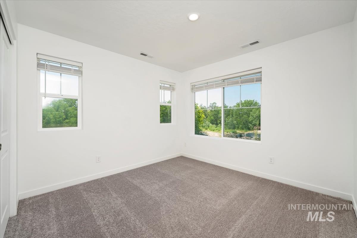 Carpeted empty room with baseboards and recessed lighting
