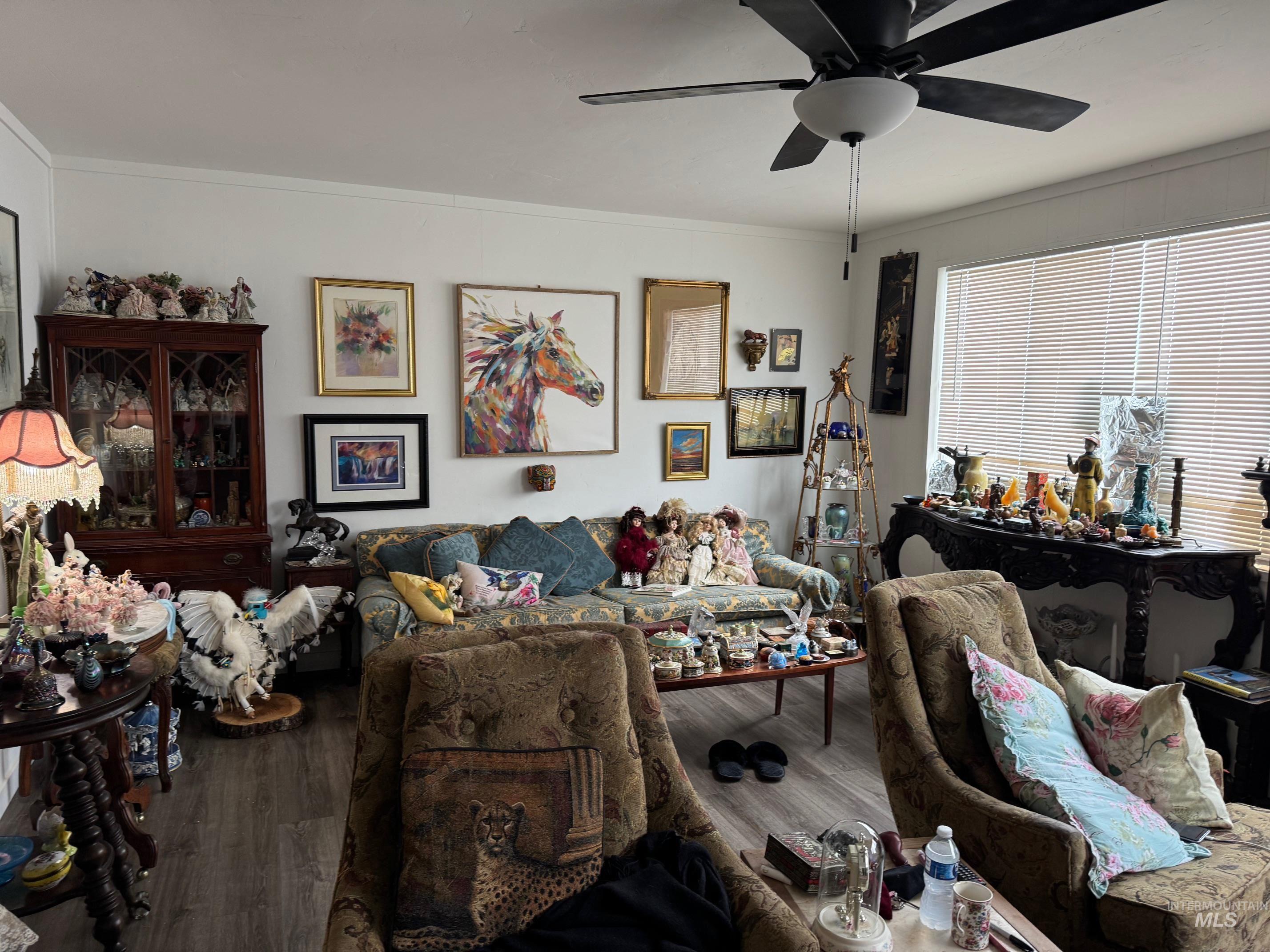 Living area featuring wood finished floors, ornamental molding, and ceiling fan