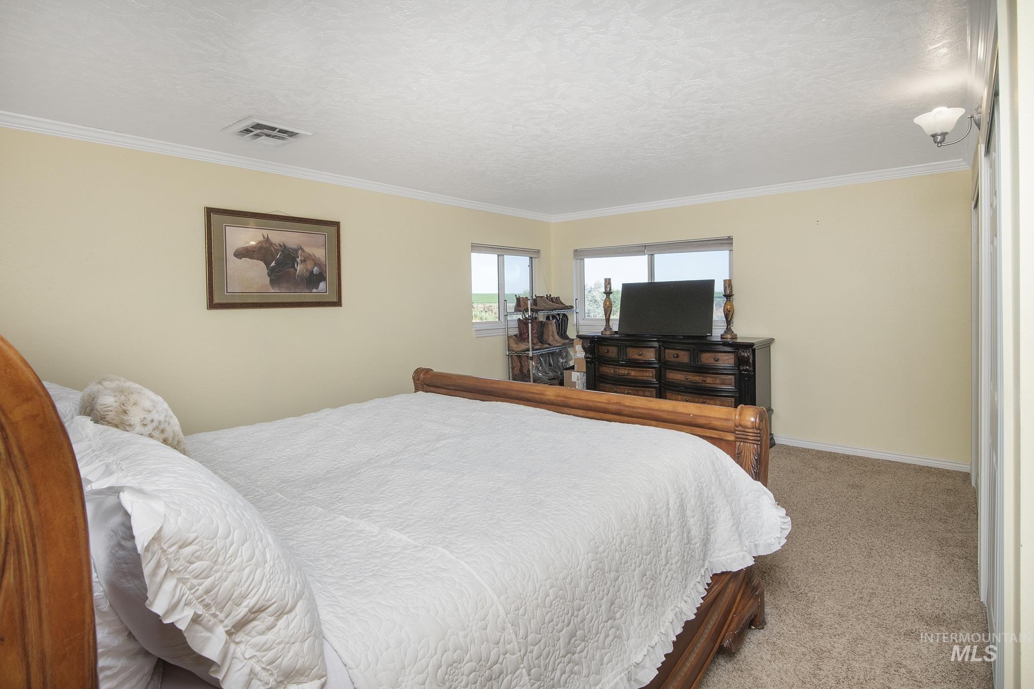 Bedroom featuring ornamental molding and carpet floors