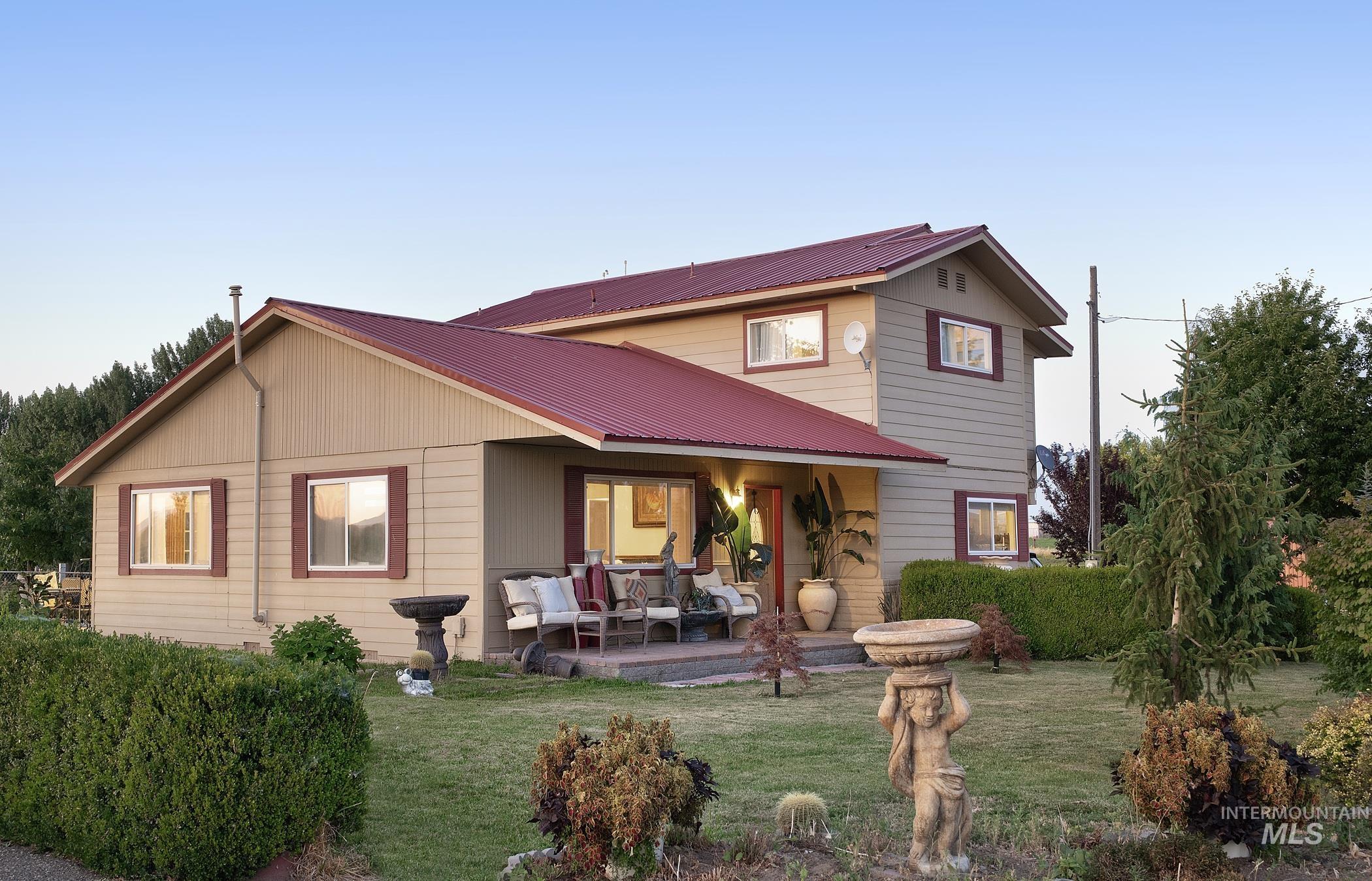 View of front of home with a metal roof, a front lawn, an outdoor living space, and a patio