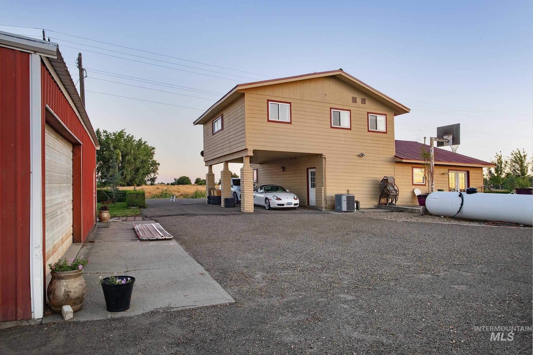 Rear view of property featuring driveway and a carport