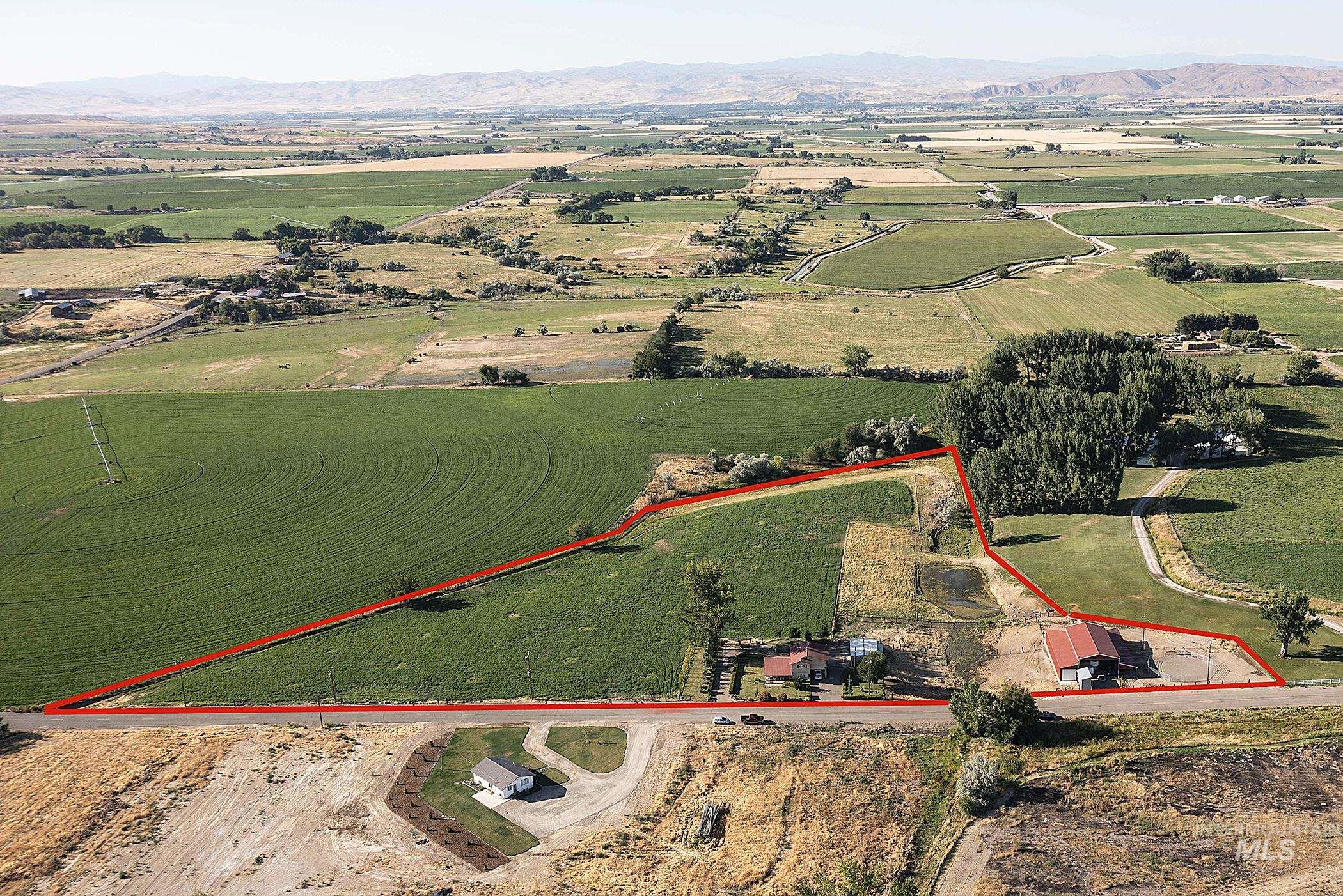 Overview of rural landscape featuring property boundaries highlighted and a mountainous background