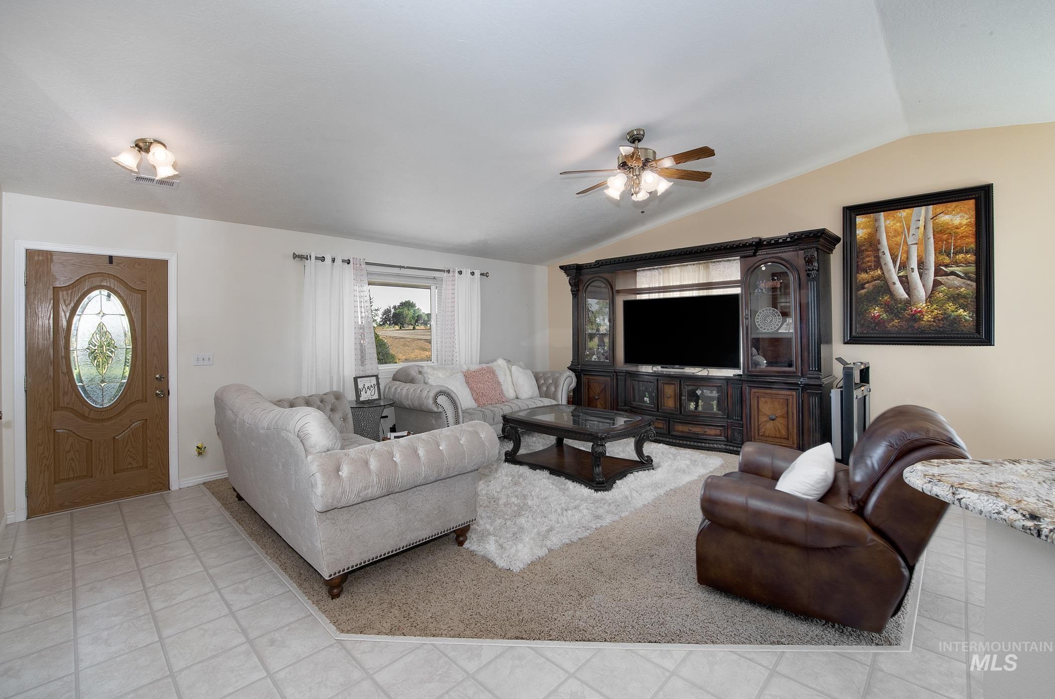 Living room with lofted ceiling and a ceiling fan