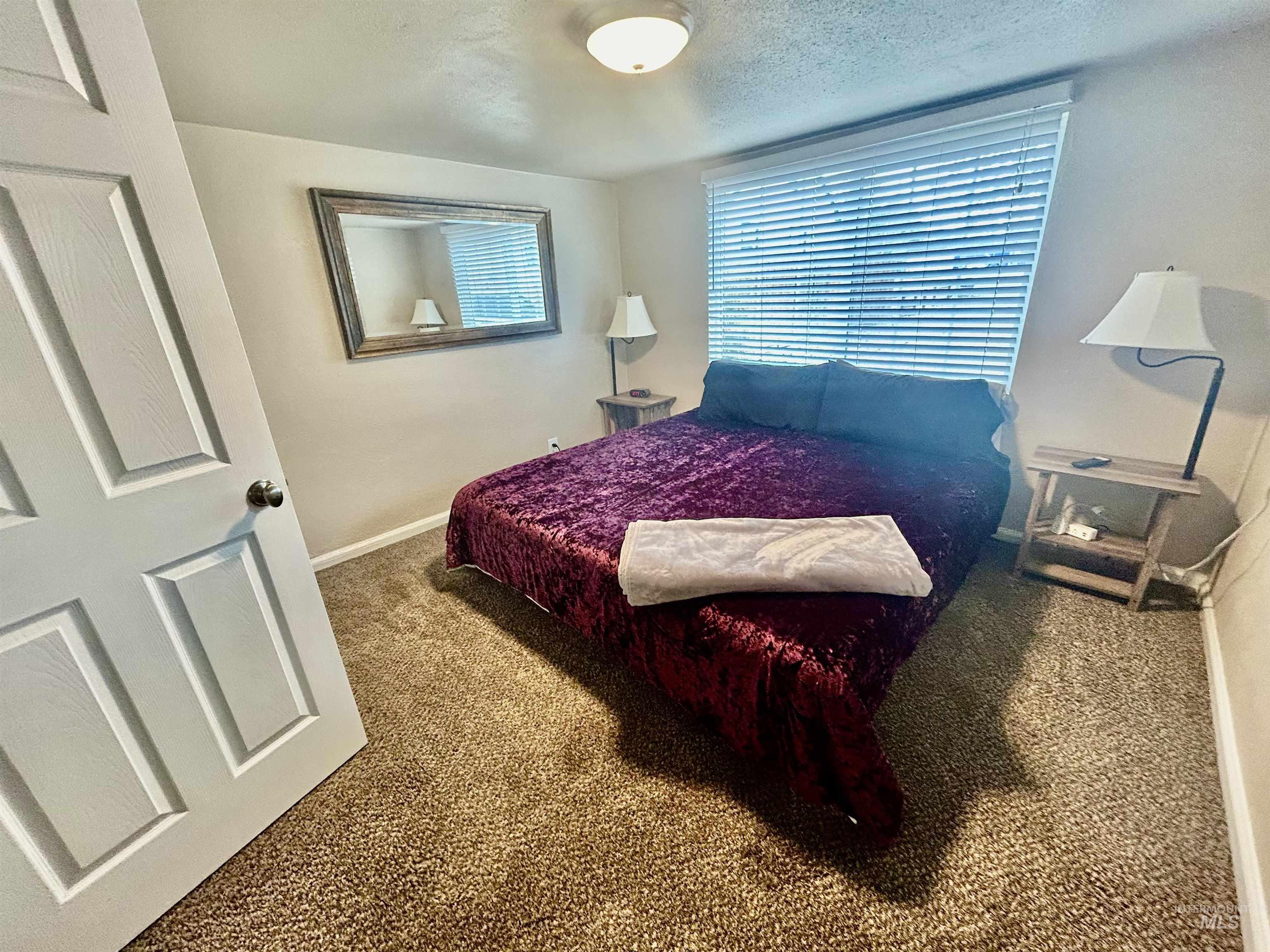 Bedroom with carpet flooring and a textured ceiling