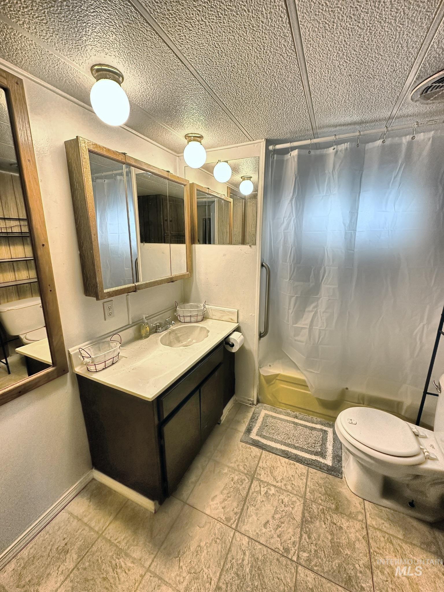 Bathroom featuring a shower with shower curtain and vanity