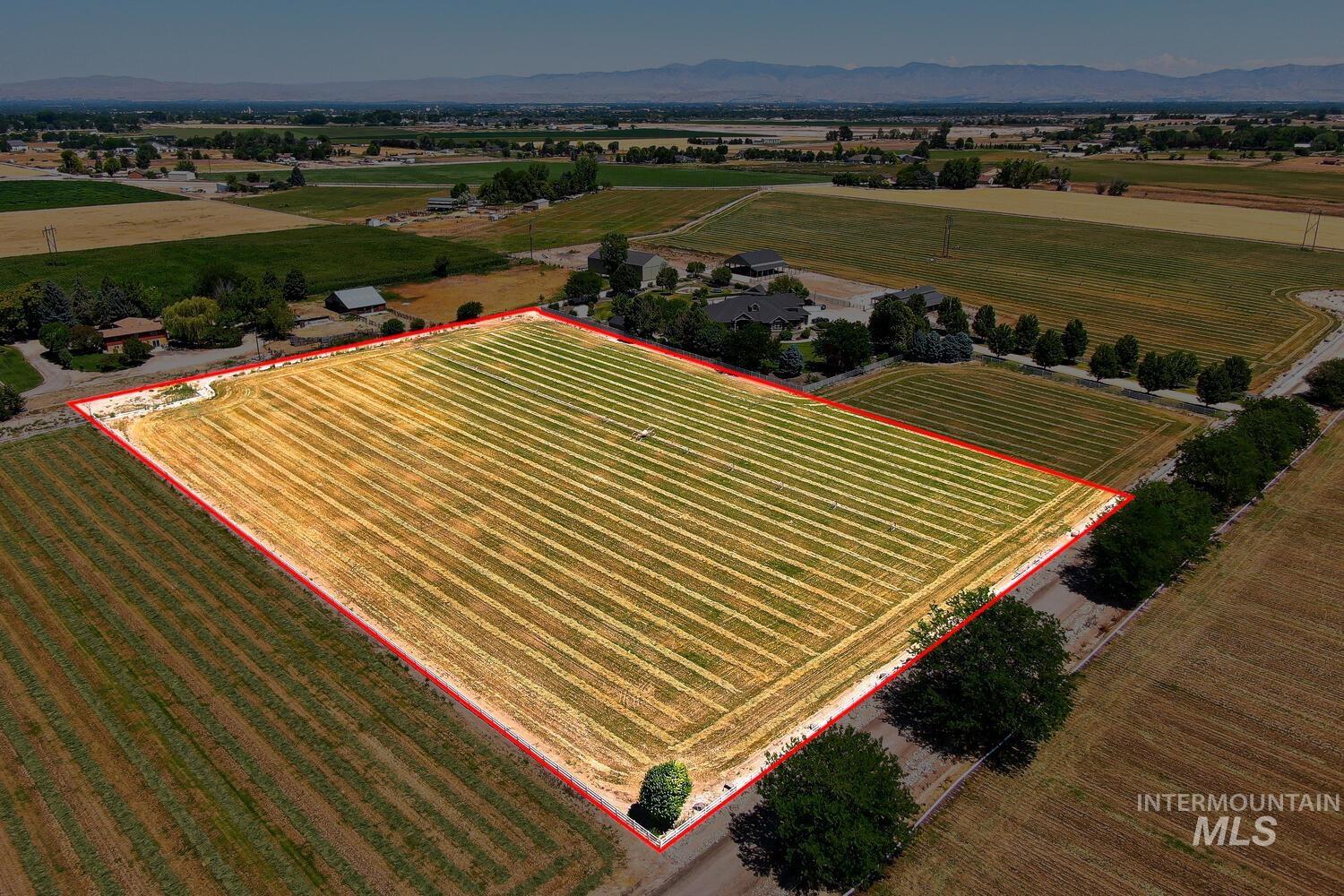 View of rural area with property parcel outlined, farmland, and mountains