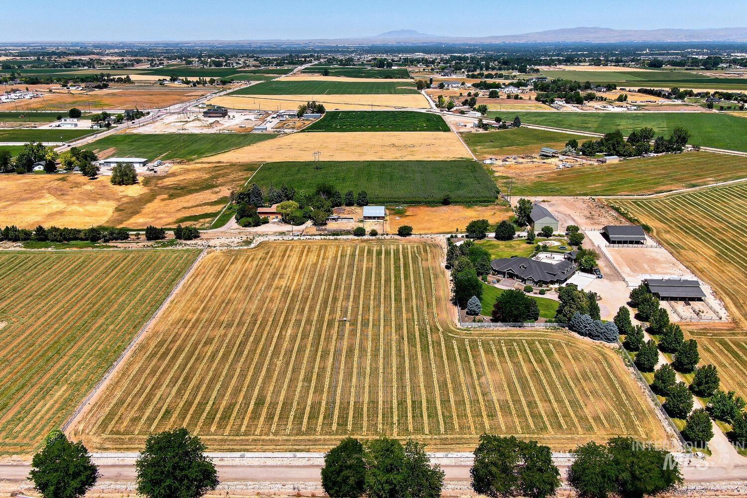 Aerial view of property and surrounding area featuring rural landscape and farmland