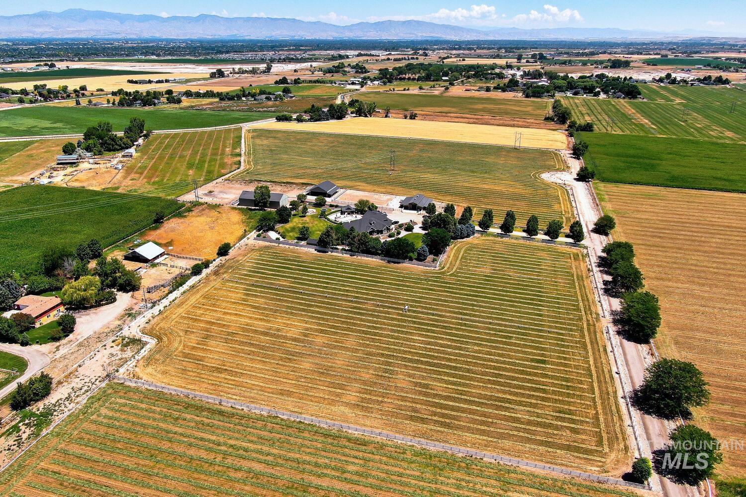 Aerial view of property and surrounding area with rural landscape and large plots for crops