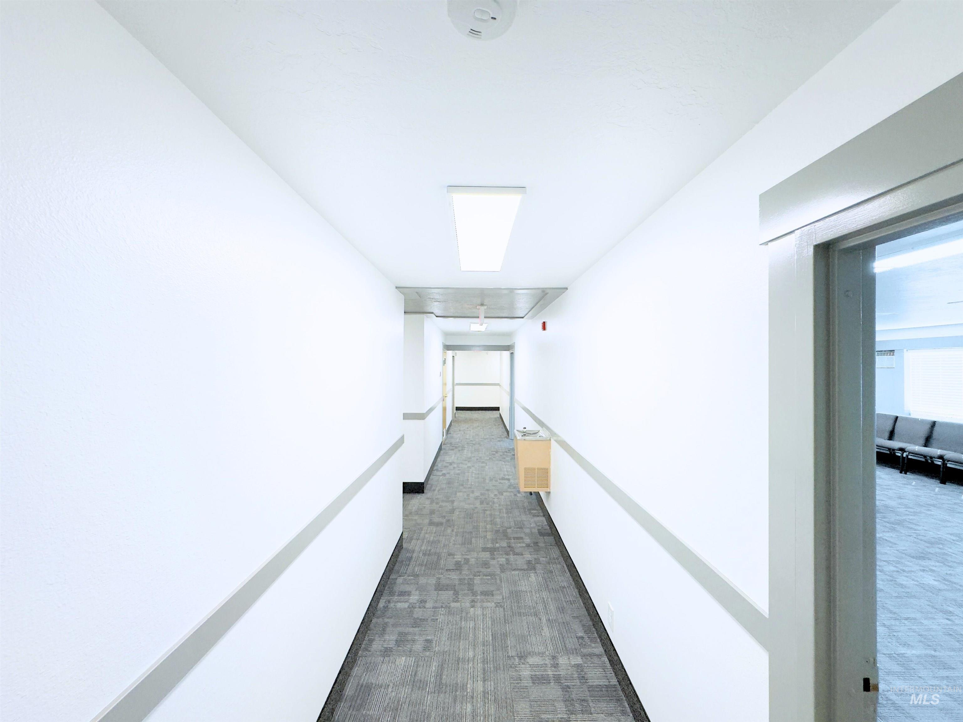 Hall with dark carpet and attic access