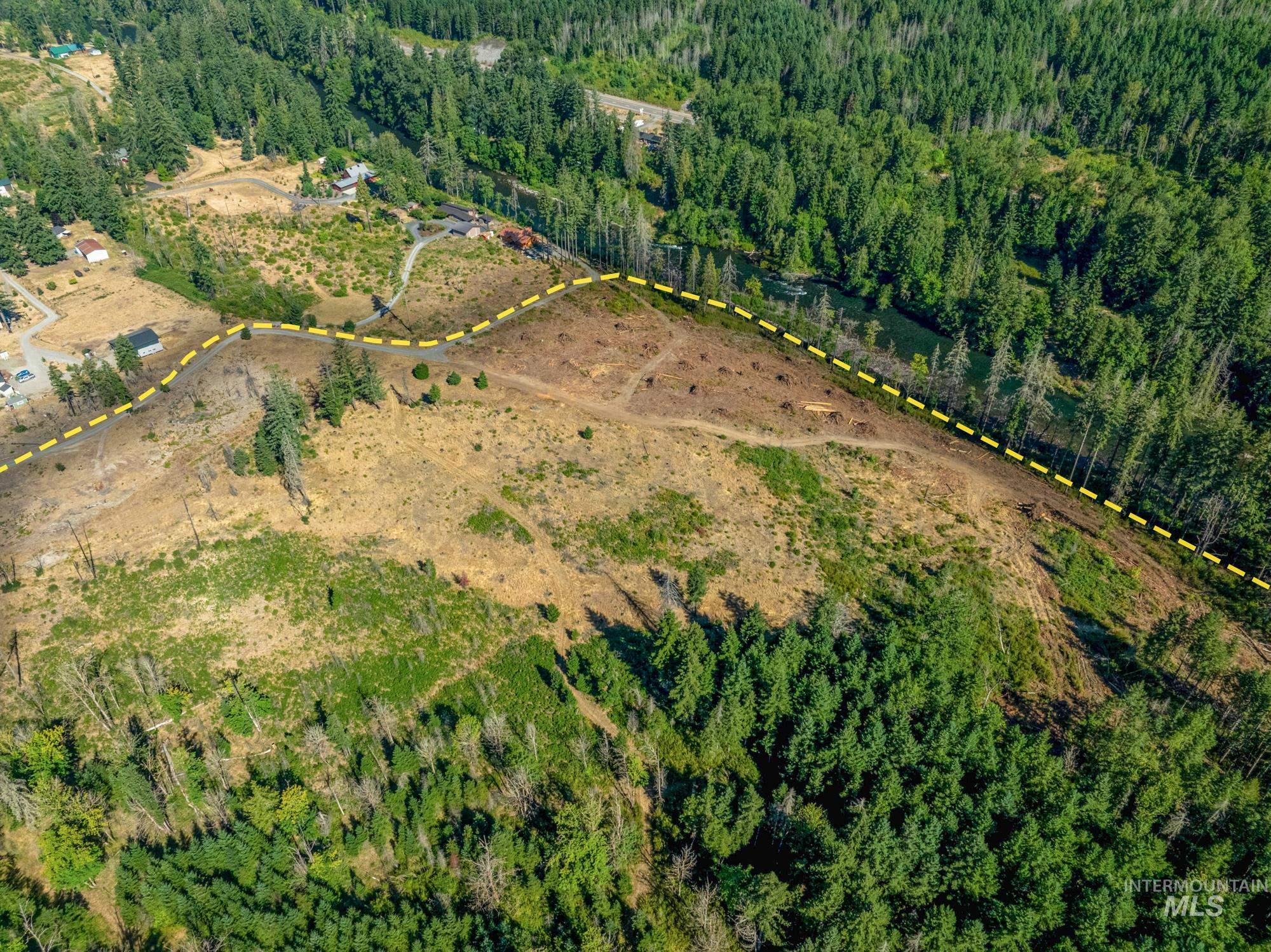 Aerial overview of property's location with a heavily wooded area and property boundaries highlighted