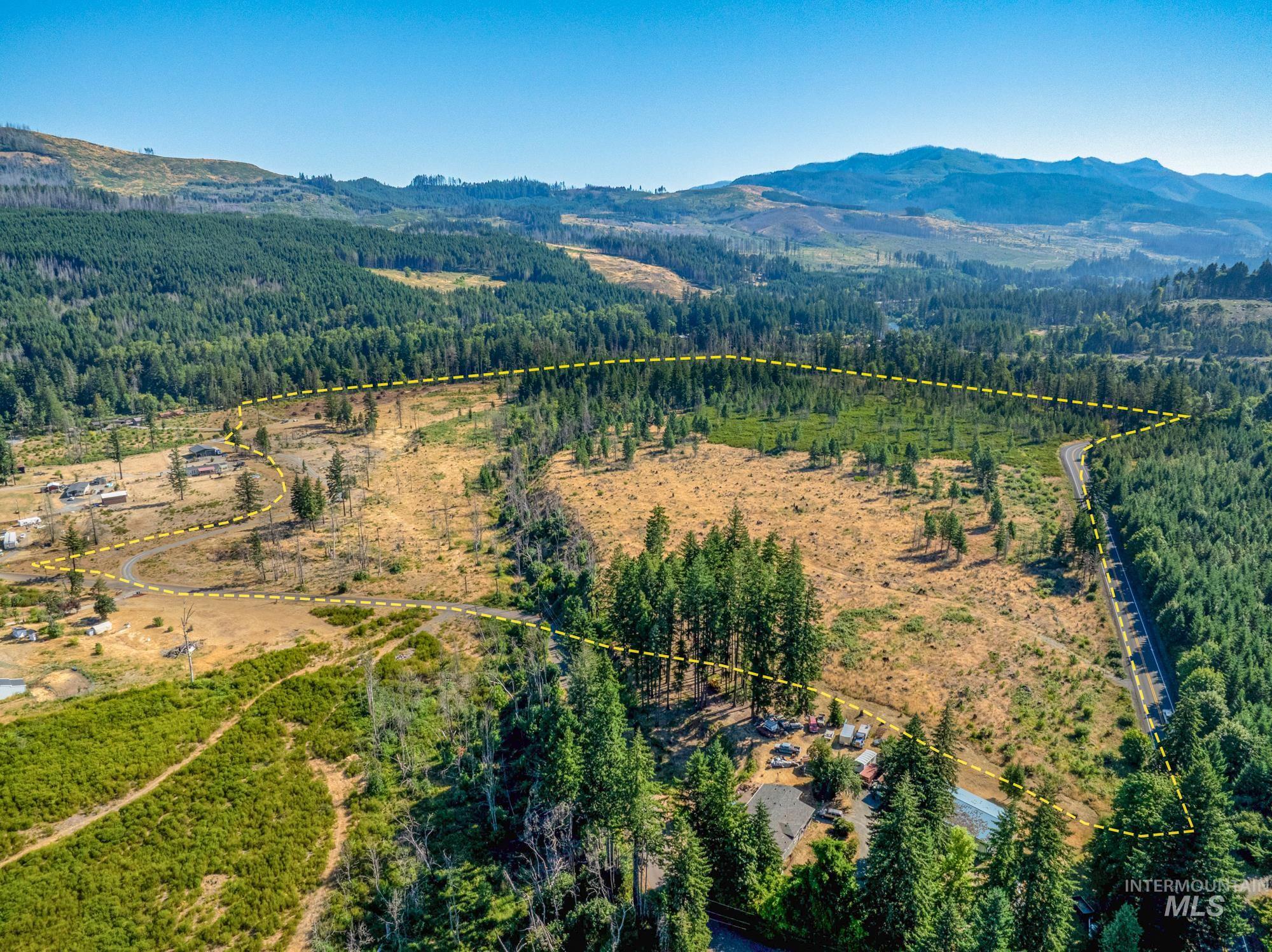 Aerial view of property and surrounding area with property boundaries highlighted and mountains