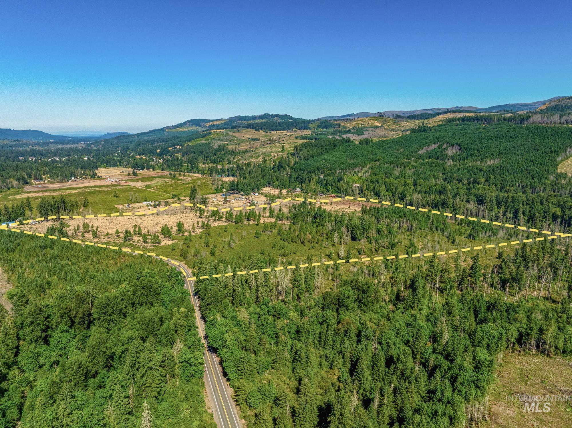 Aerial view of property and surrounding area with property boundaries highlighted and a mountainous background