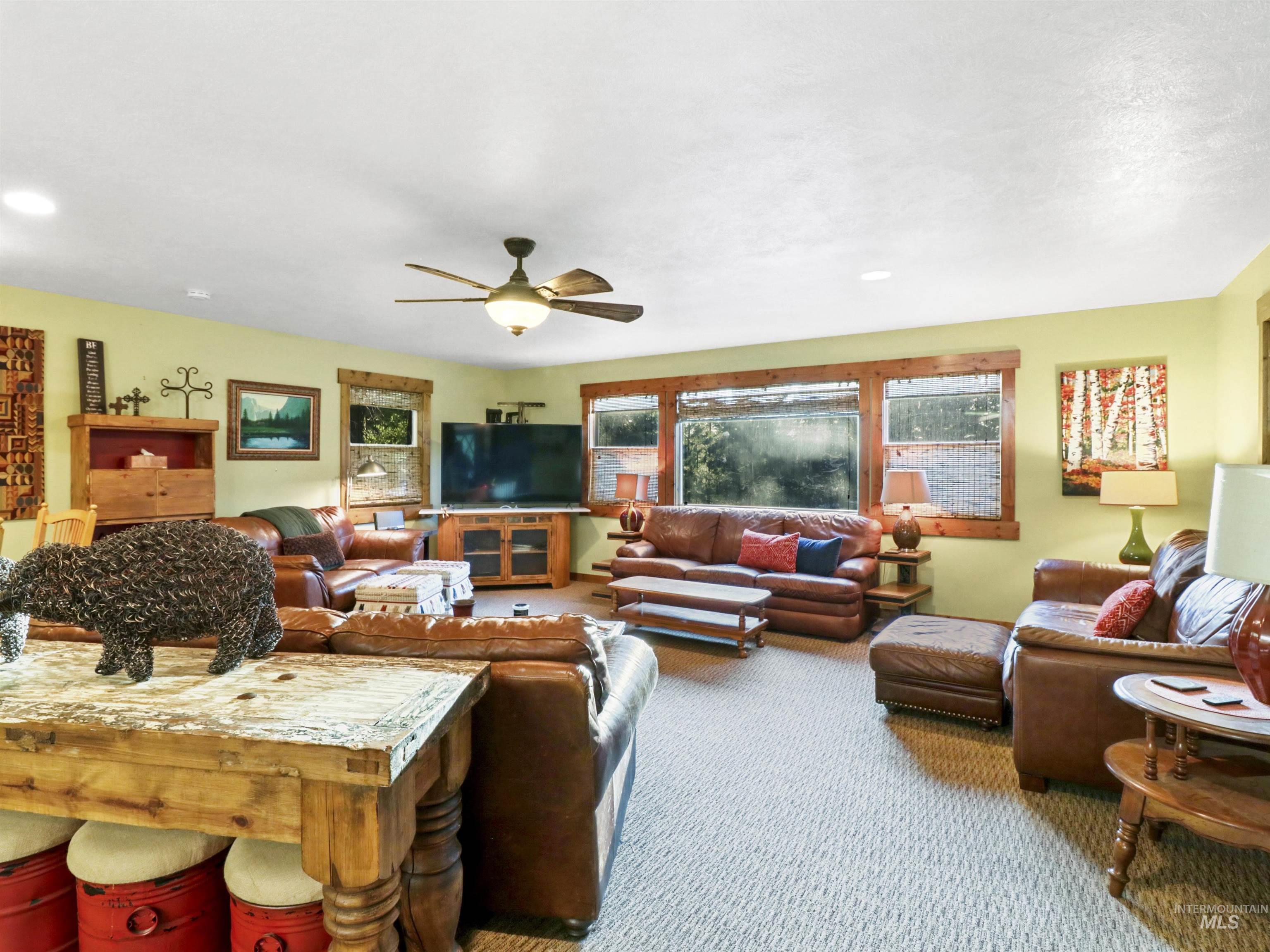 Living room featuring carpet flooring, a ceiling fan, and recessed lighting