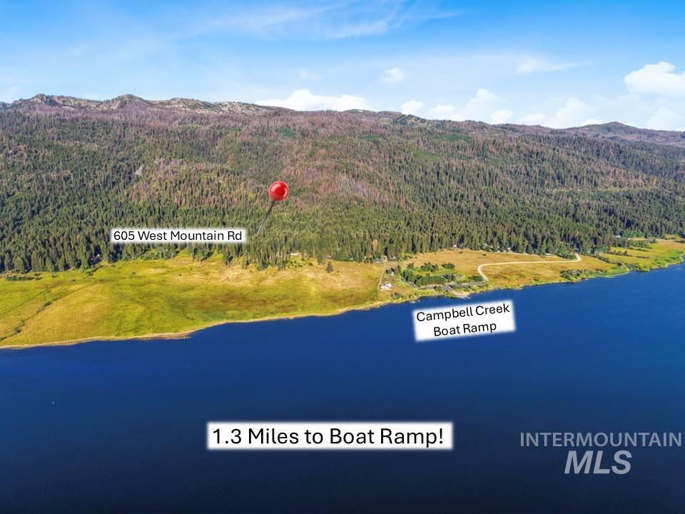 Drone / aerial view of a heavily wooded area and a water and mountain view