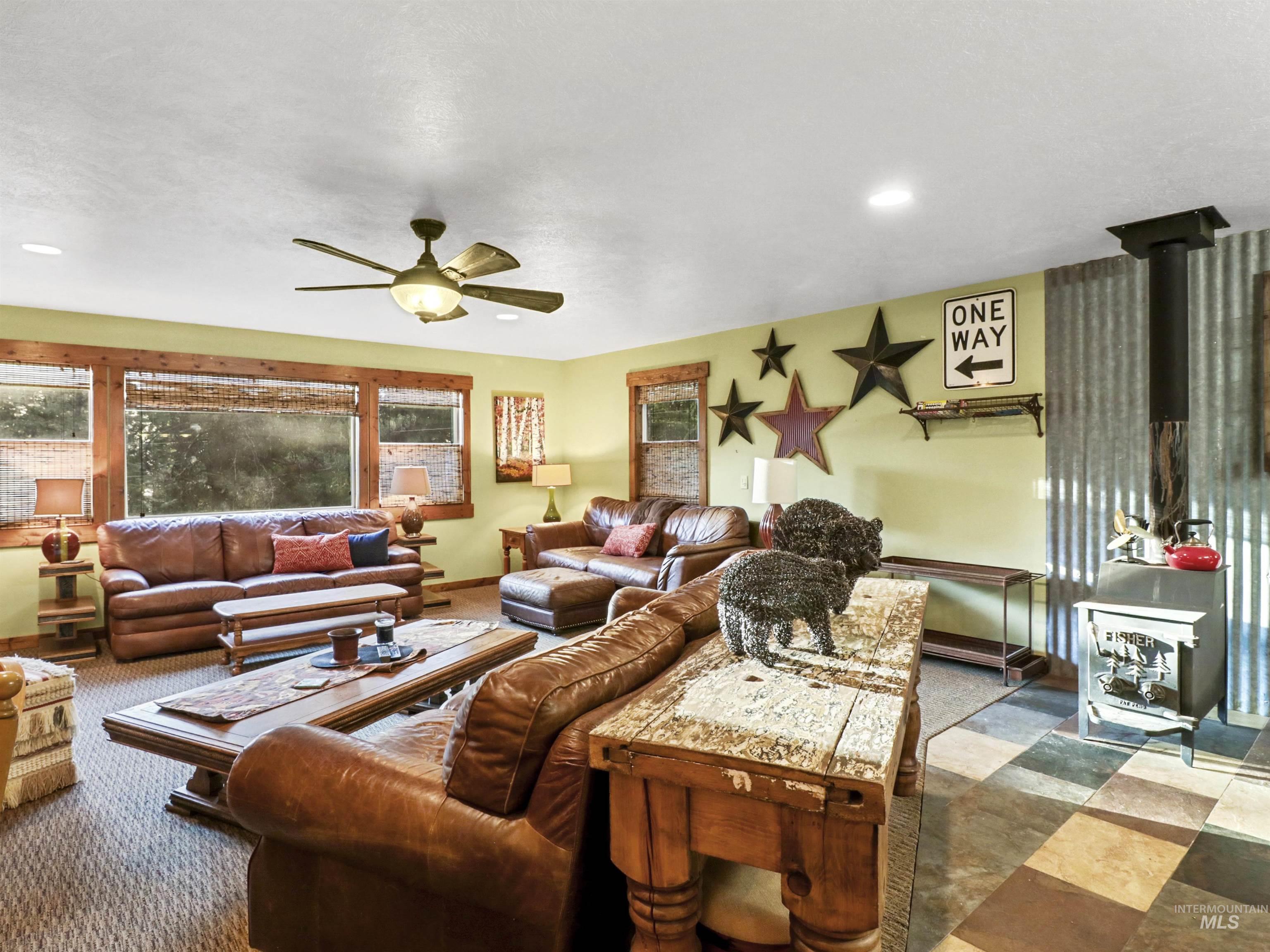 Carpeted living area with a wood stove, ceiling fan, and recessed lighting