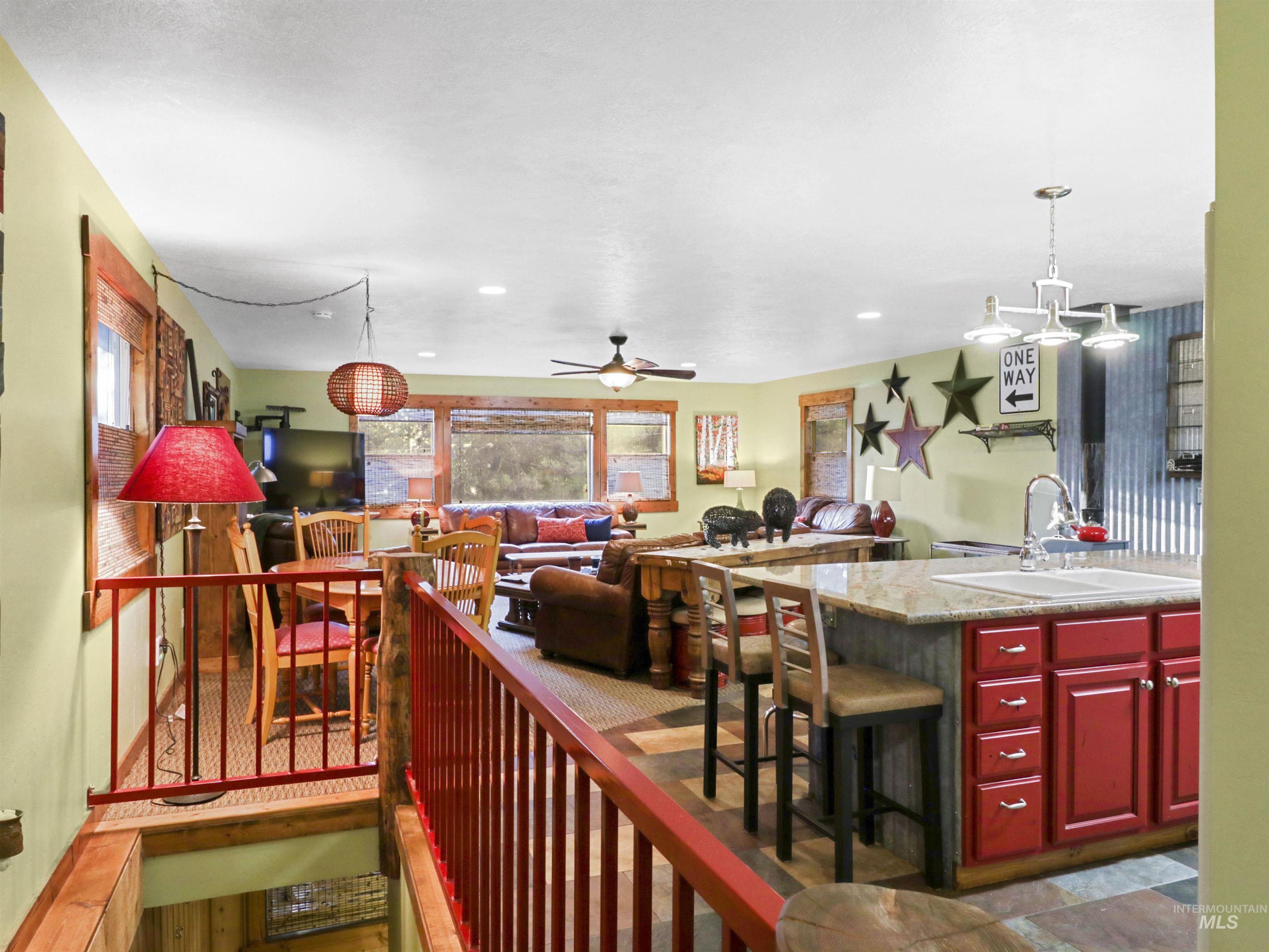 Kitchen with open floor plan, a ceiling fan, decorative light fixtures, reddish brown cabinets, and recessed lighting